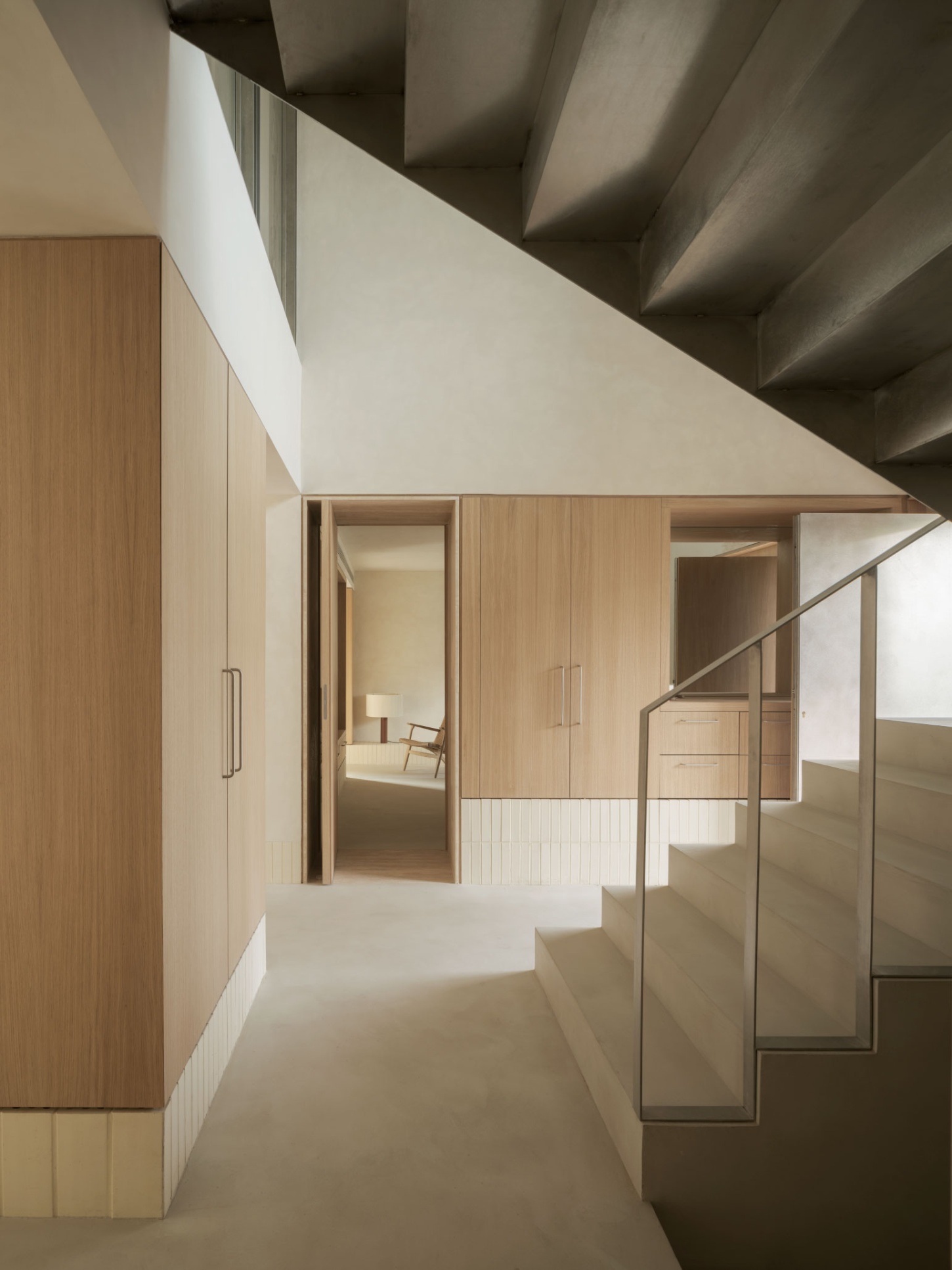 Casa SO by Studio DIIR — A timber-lined corridor extends toward a distant bedroom, its narrowing perspective emphasizing spatial compression before release.