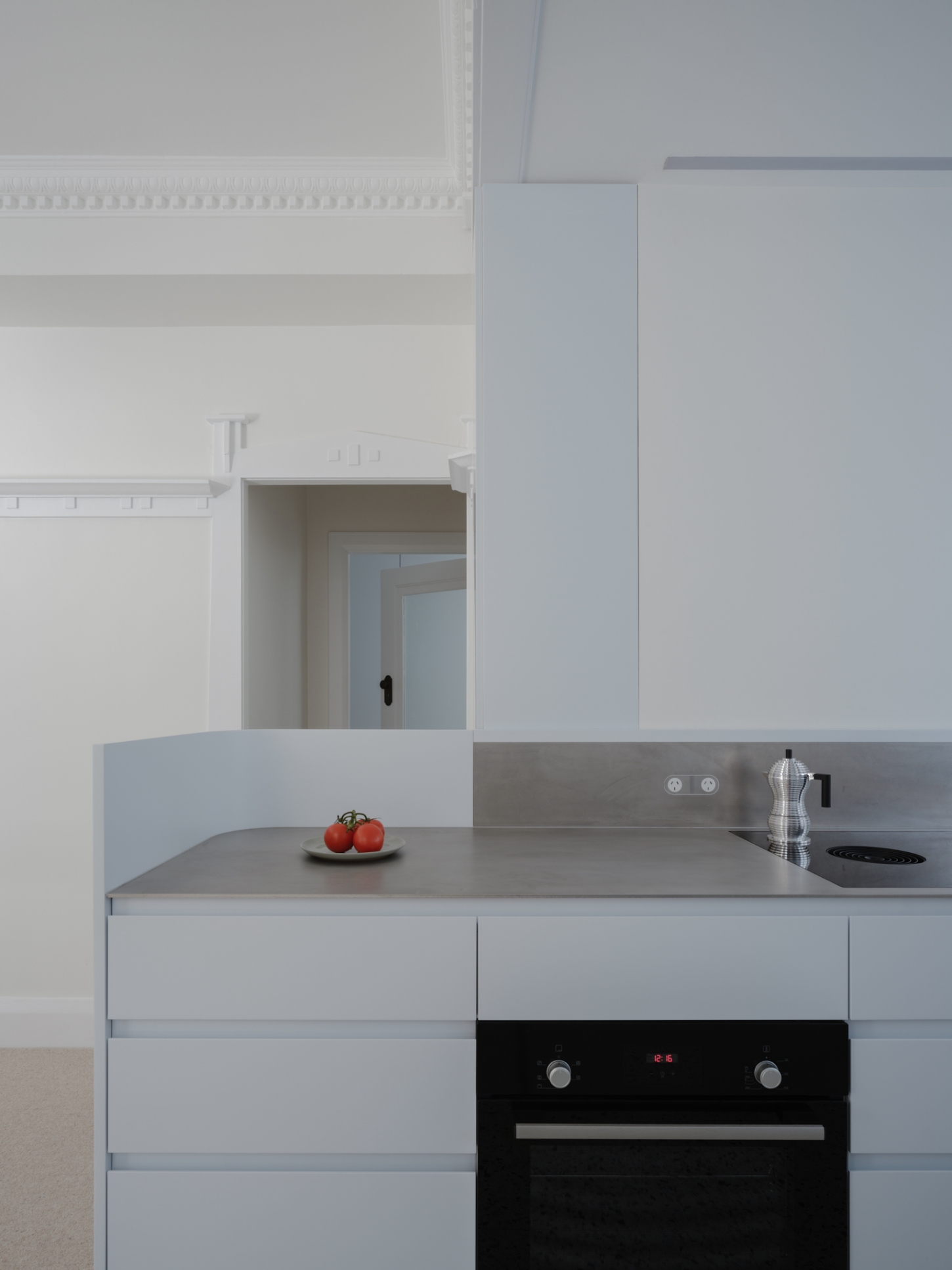 Onslow Gardens Apartment by Youssofzay Hart — The kitchen counter presents a minimalist composition centered on utility and restraint.