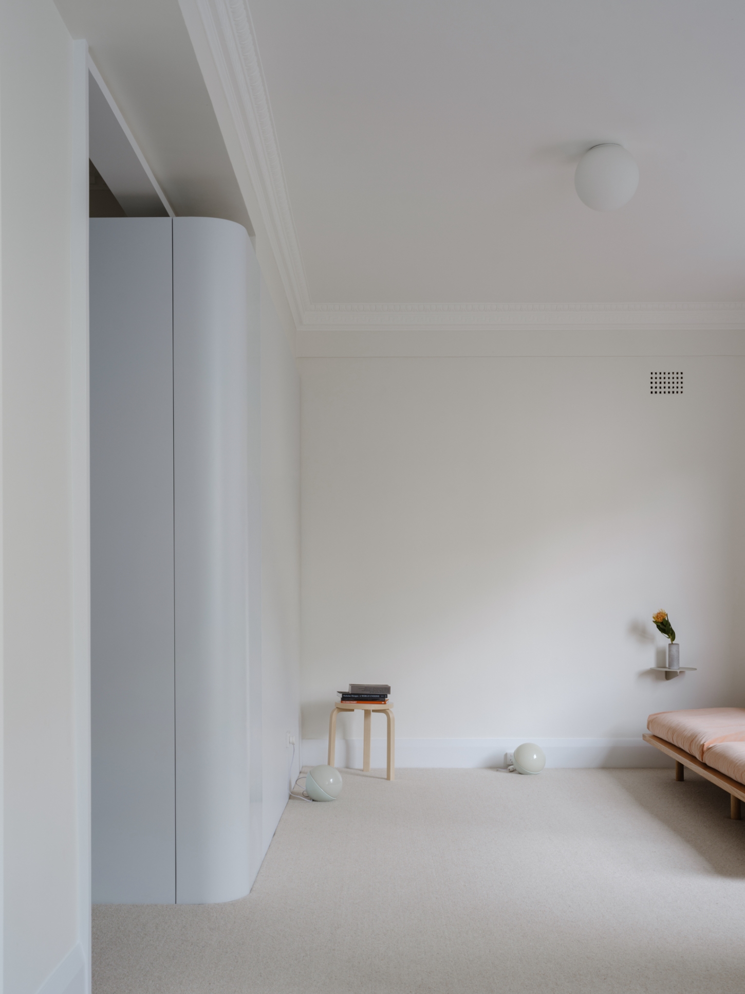 Onslow Gardens Apartment by Youssofzay Hart — A minimalist bedroom viewed from the threshold, framed by white architrave creating a layered entrance.