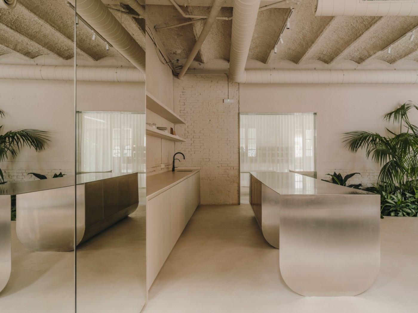 Blow Studio by Isern Serra — A central atrium space carved from the warehouse volume, flooded with zenithal light through a newly cut skylight.