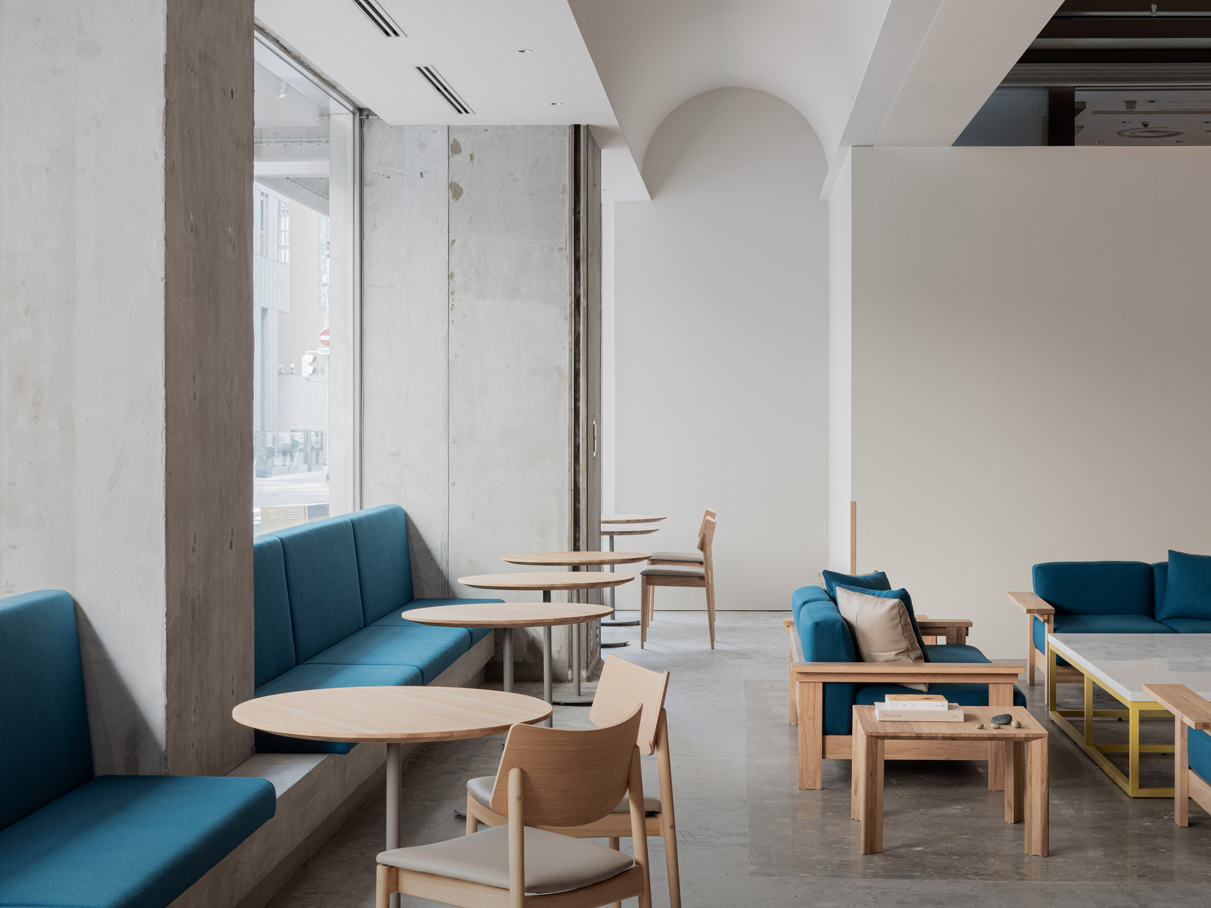 Blue Bottle Coffee Kobe Hankyu Cafe by Keiji Ashizawa — The café interior reveals a layered spatial strategy centered on seating arrangements and material contrast.