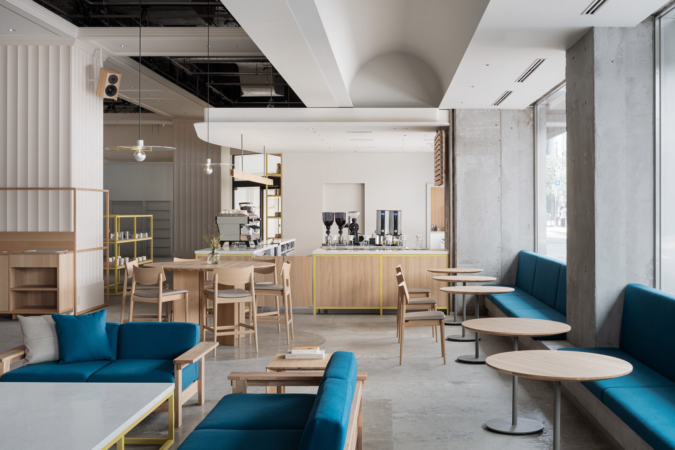 Blue Bottle Coffee Kobe Hankyu Cafe by Keiji Ashizawa — The café interior demonstrates spatial hierarchy through material and colour differentiation.