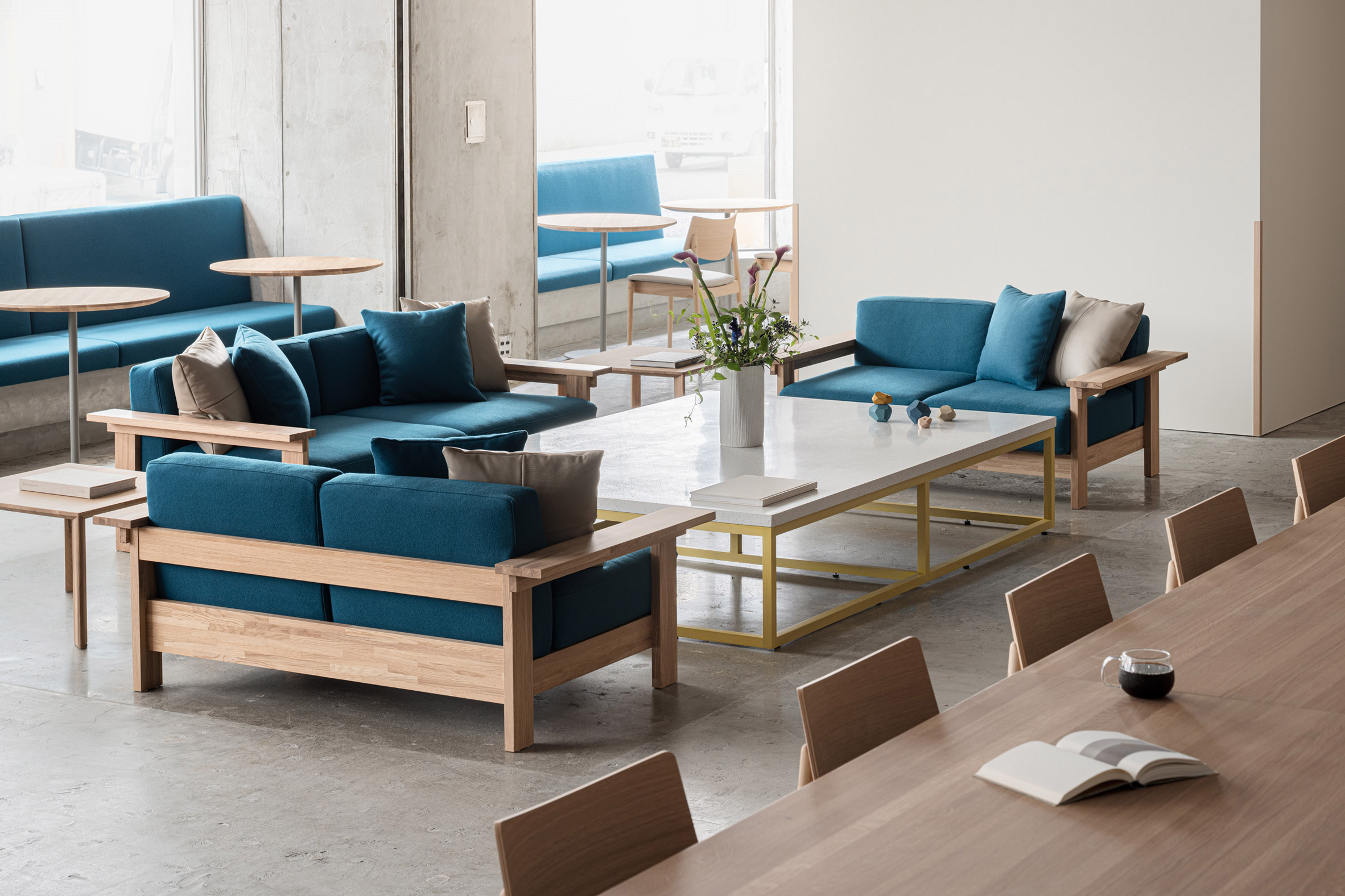Blue Bottle Coffee Kobe Hankyu Cafe by Keiji Ashizawa — This lounge seating vignette demonstrates Ashizawa's material palette through a congregation of custom-designed furniture pieces arranged around a central...