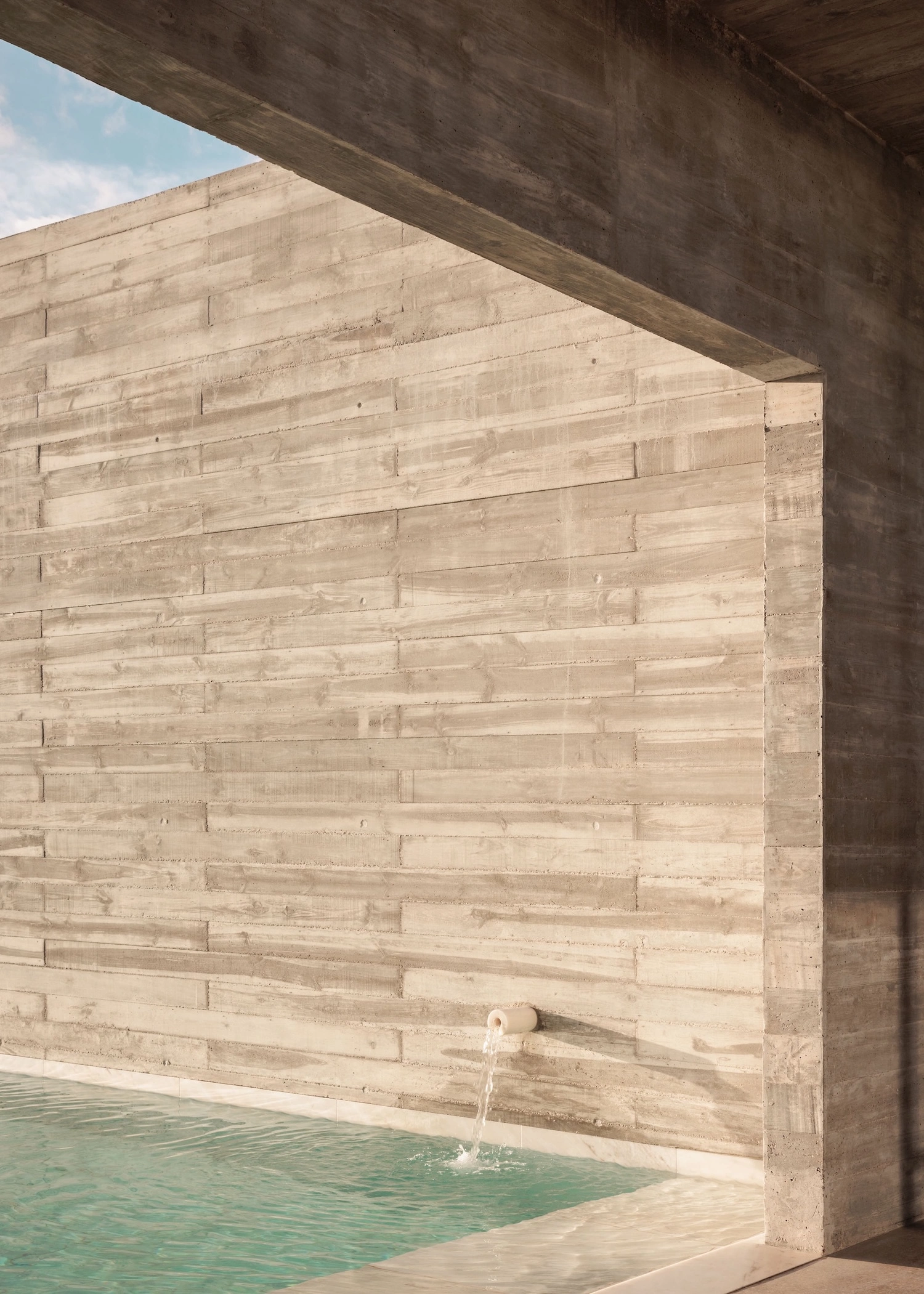 Frame House by Pedro Domingos Arquitectos — A timber-clad interior wall dominates the frame, constructed from horizontal planks in light pine or similar wood material, displaying consistent...