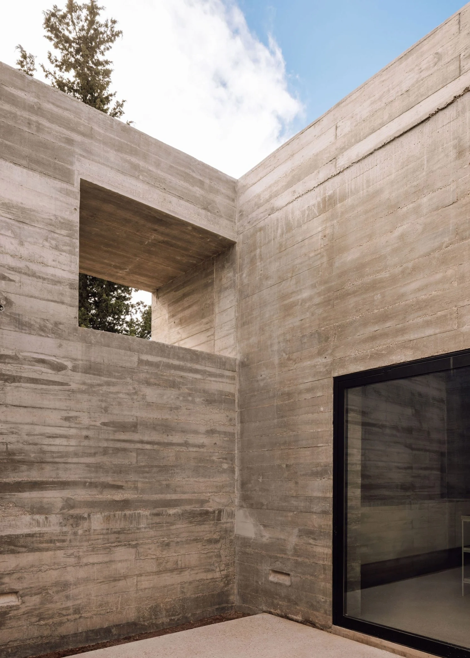 Frame House by Pedro Domingos Arquitectos — A corner view of the concrete structure reveals the interplay of volumetric mass and void.