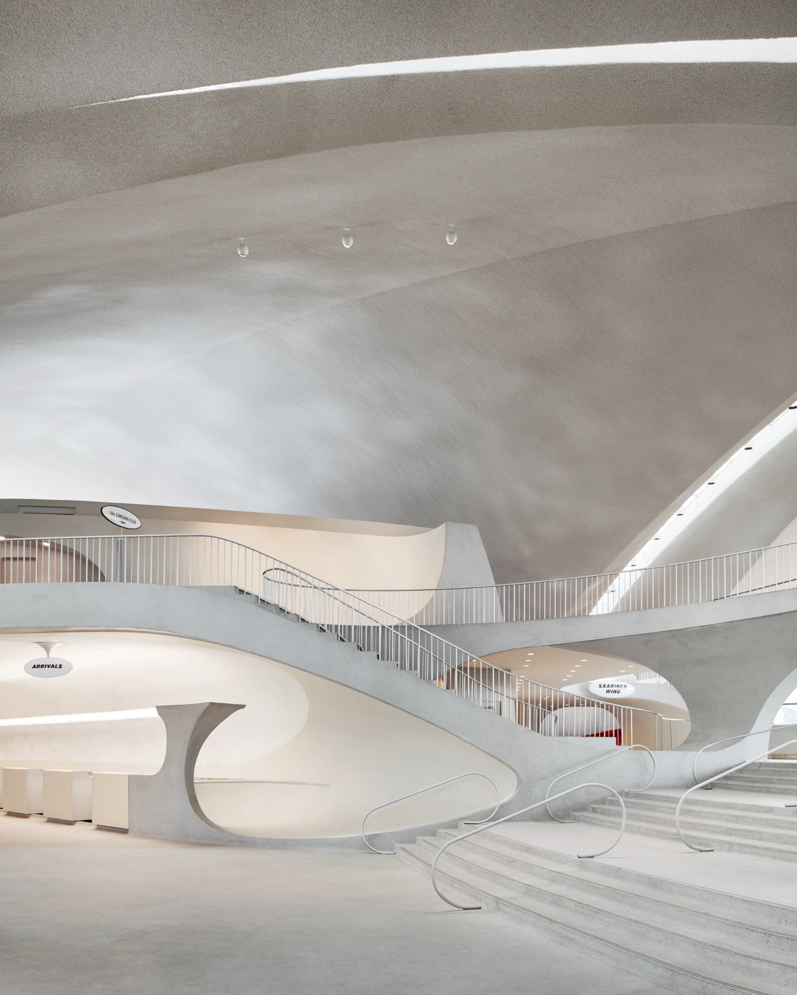 TWA Hotel by Eero Saarinen — The TWA Hotel's arrivals hall demonstrates Saarinen's sculptural approach to concrete through a dramatically vaulted ceiling that curves overhead like an...