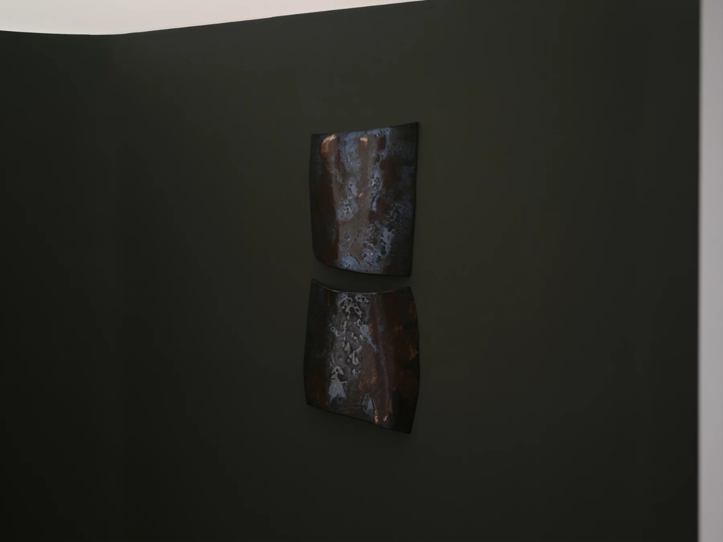 ‘Untitled’ by JAMESPLUMB & Garcé Dimofski at Francis Gallery — Two weathered stone objects mounted vertically on a dark wall, stacked with subtle spatial separation.