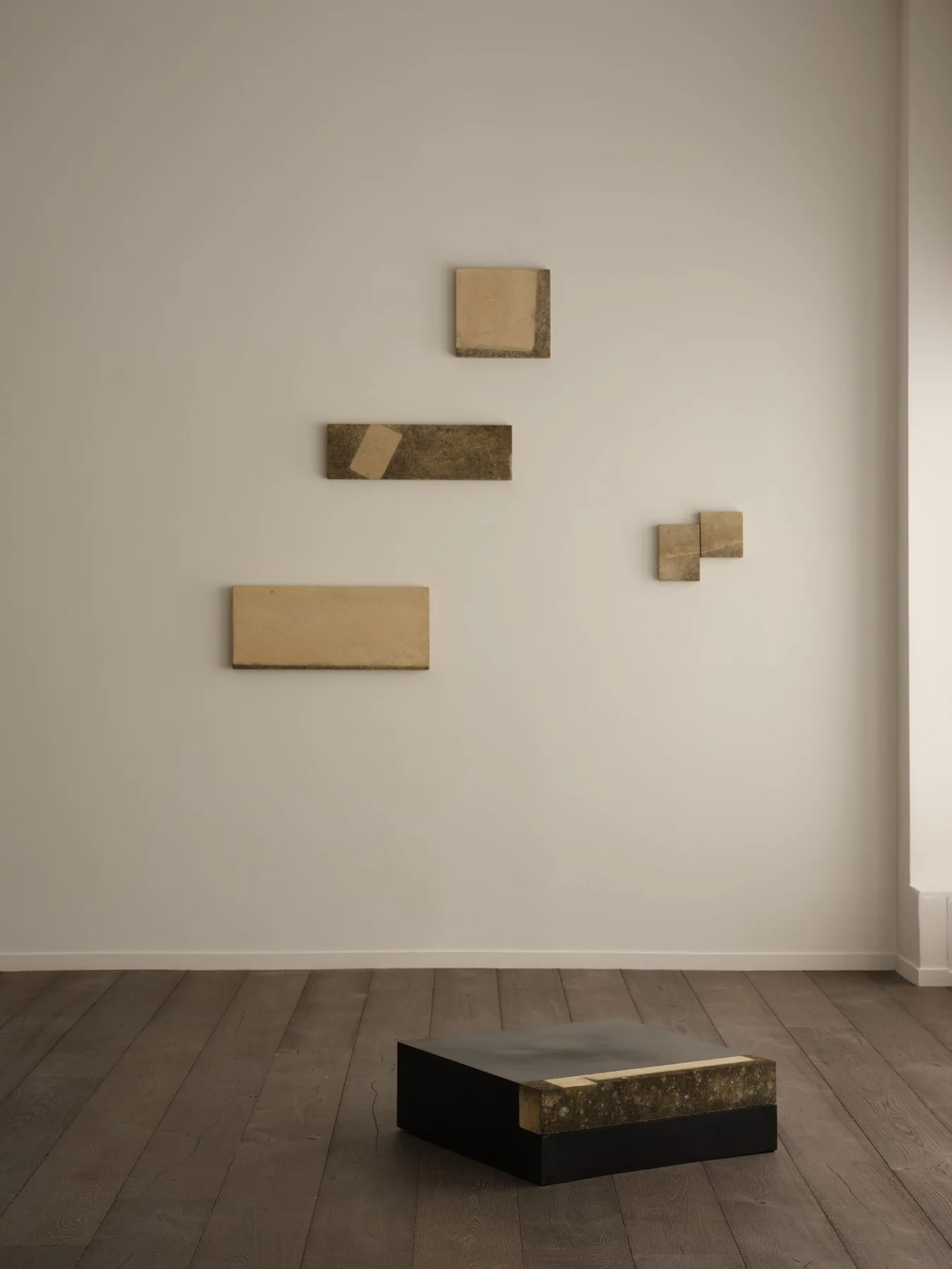‘Untitled’ by JAMESPLUMB & Garcé Dimofski at Francis Gallery — Installation view presenting five stone fragments mounted on white gallery wall in asymmetric arrangement, ranging from small square element at top to...