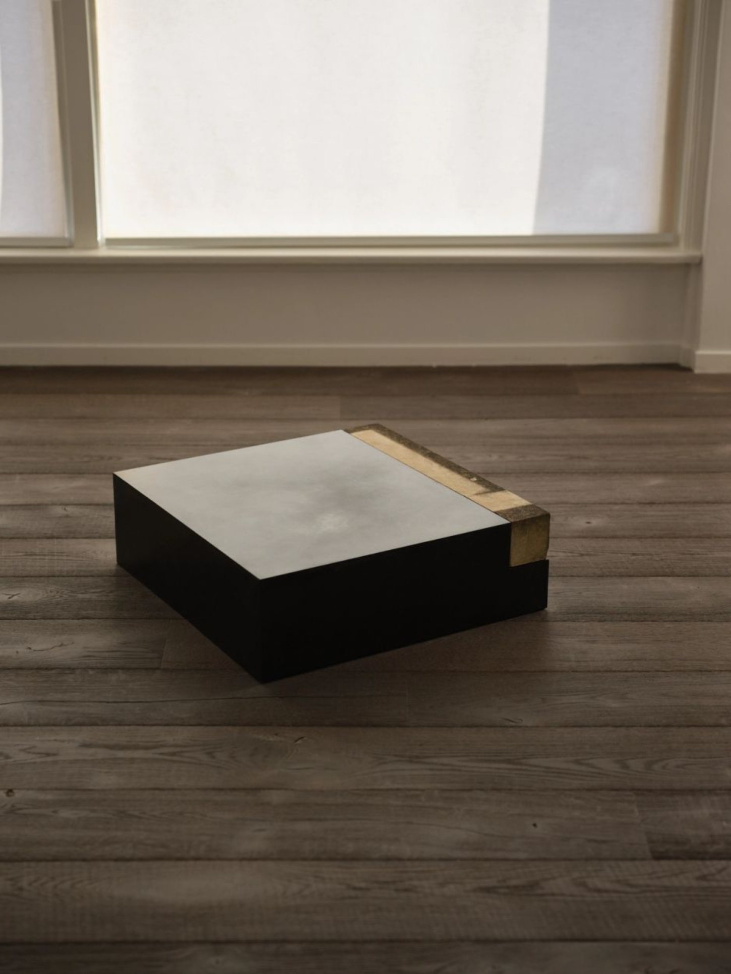 ‘Untitled’ by JAMESPLUMB & Garcé Dimofski at Francis Gallery — A floor-mounted plinth in black supports a rectangular stone top with a pale cream surface exhibiting subtle weathering patterns.