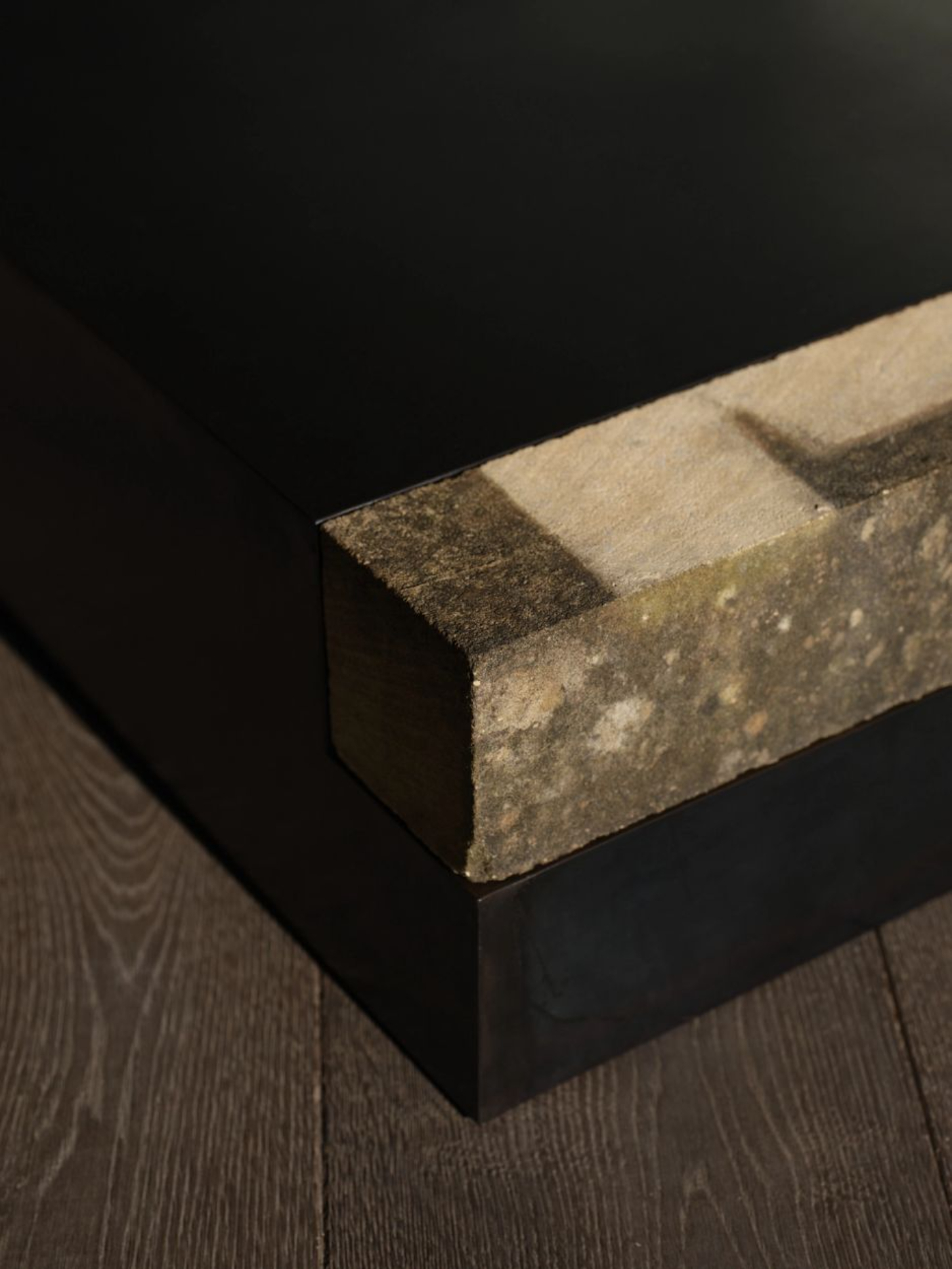 ‘Untitled’ by JAMESPLUMB & Garcé Dimofski at Francis Gallery — A single floor-mounted sculptural object anchors the composition: weathered stone positioned atop a black plinth.