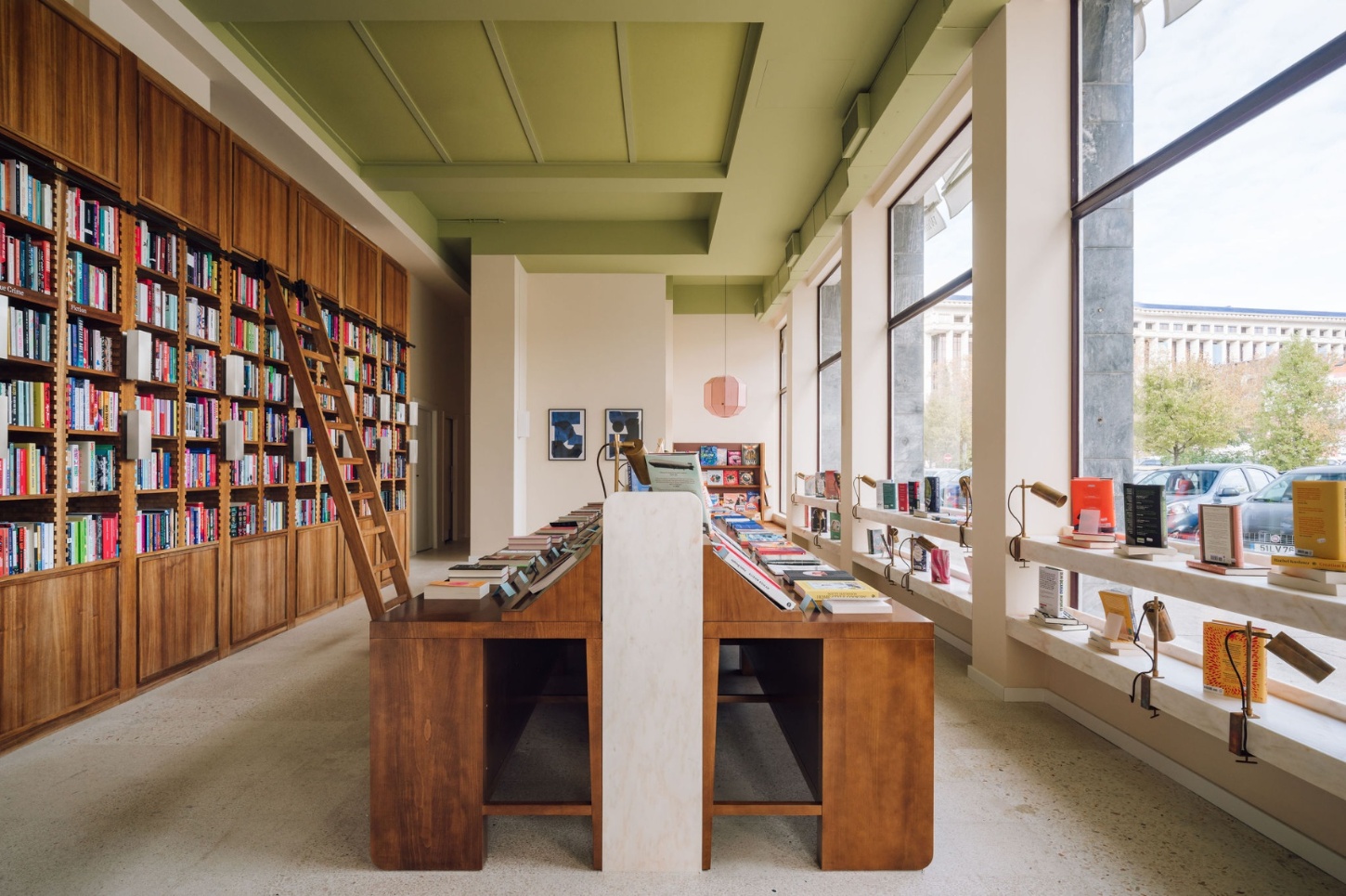 Good Company Books by Studio PIM — Good Company Books reveals a methodical interior organized around two timber display pedestals with angled shelving surfaces running the length of the...