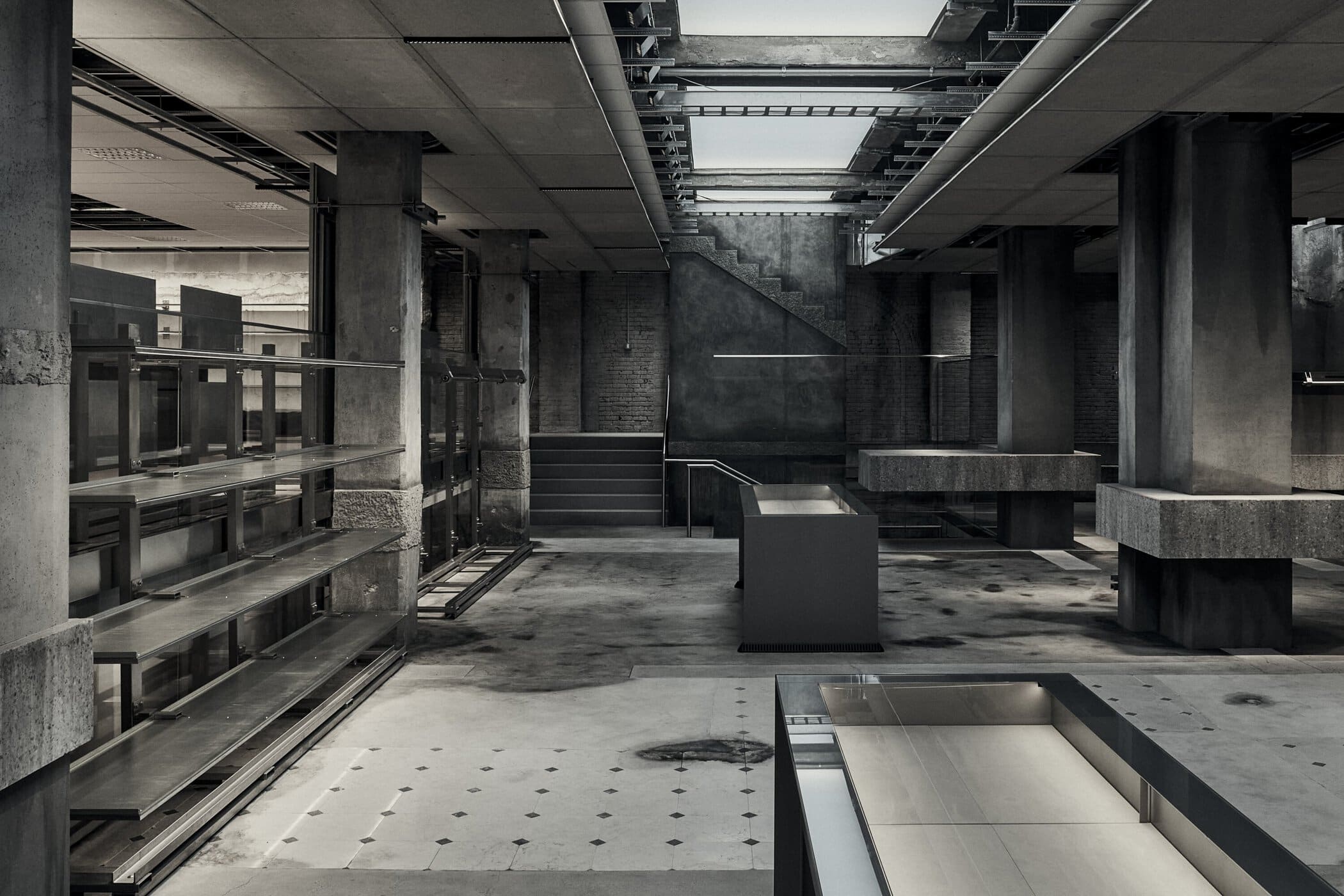 Balenciaga Greene Street Flagship Store in New York — The ground floor reveals the structural skeleton of the 1908 building through exposed steel beams and concrete support columns arranged in a regular grid.