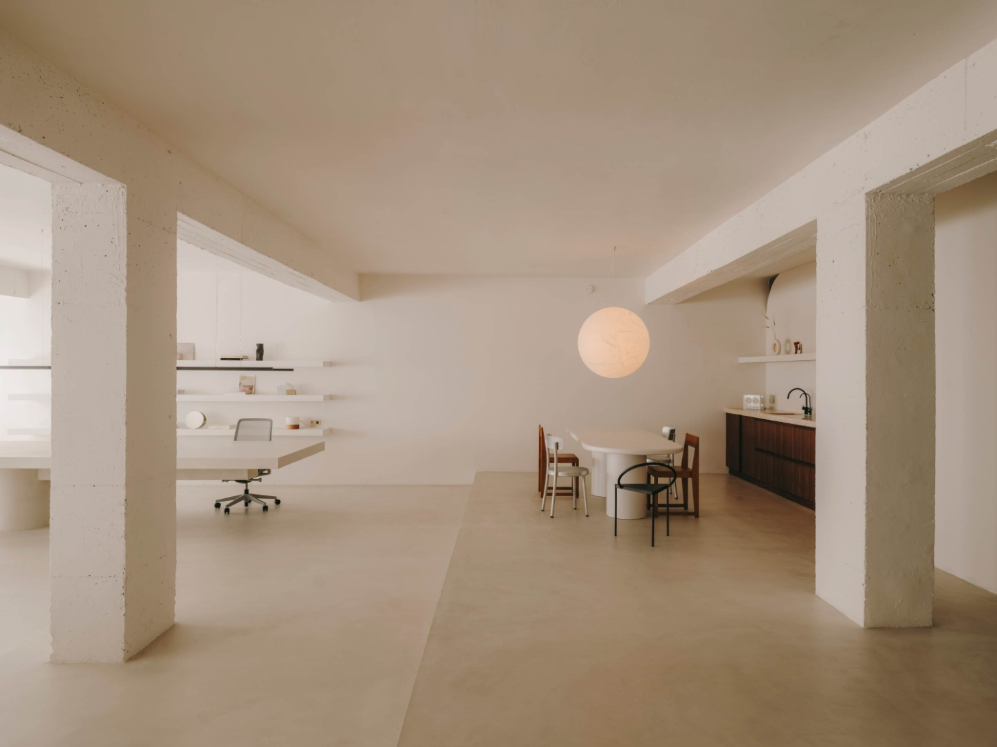 Isern Serra Studio — A 200-square-meter open-plan interior defined by structural concrete columns and whitewashed walls that establish zones for work and living.