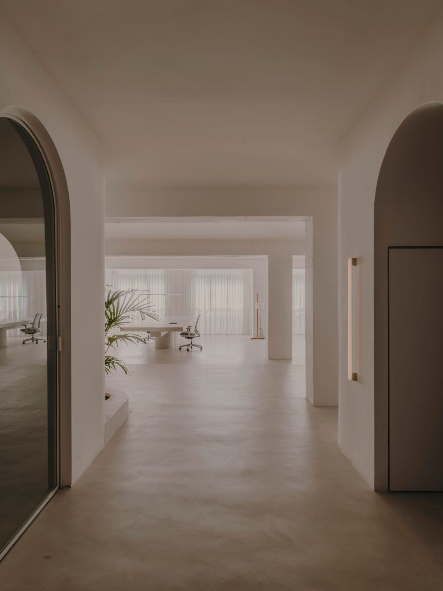 Isern Serra Studio — A corridor with arched openings frames the studio's 200-square-meter plan, revealing layered spatial depth through receding archways.