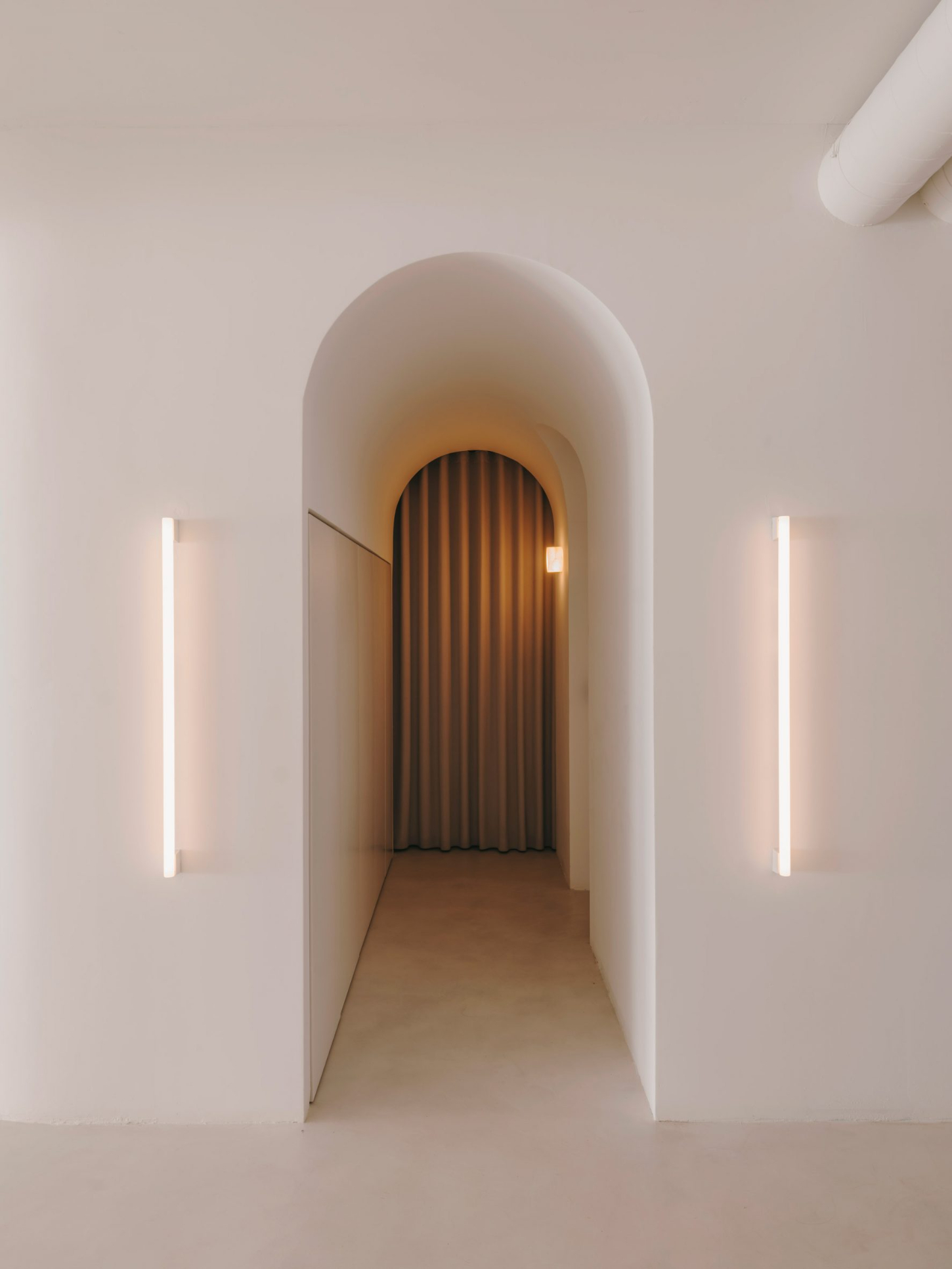 Isern Serra Studio — A rendered archway frames a narrow passage flooded with golden light from an unseen source.