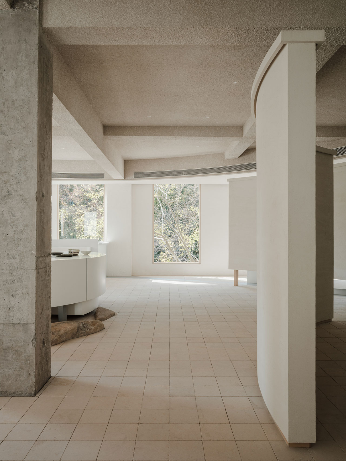 JIA Garden by Mountain Soil — A longitudinal interior passage defined by concrete structural columns and white-rendered walls.