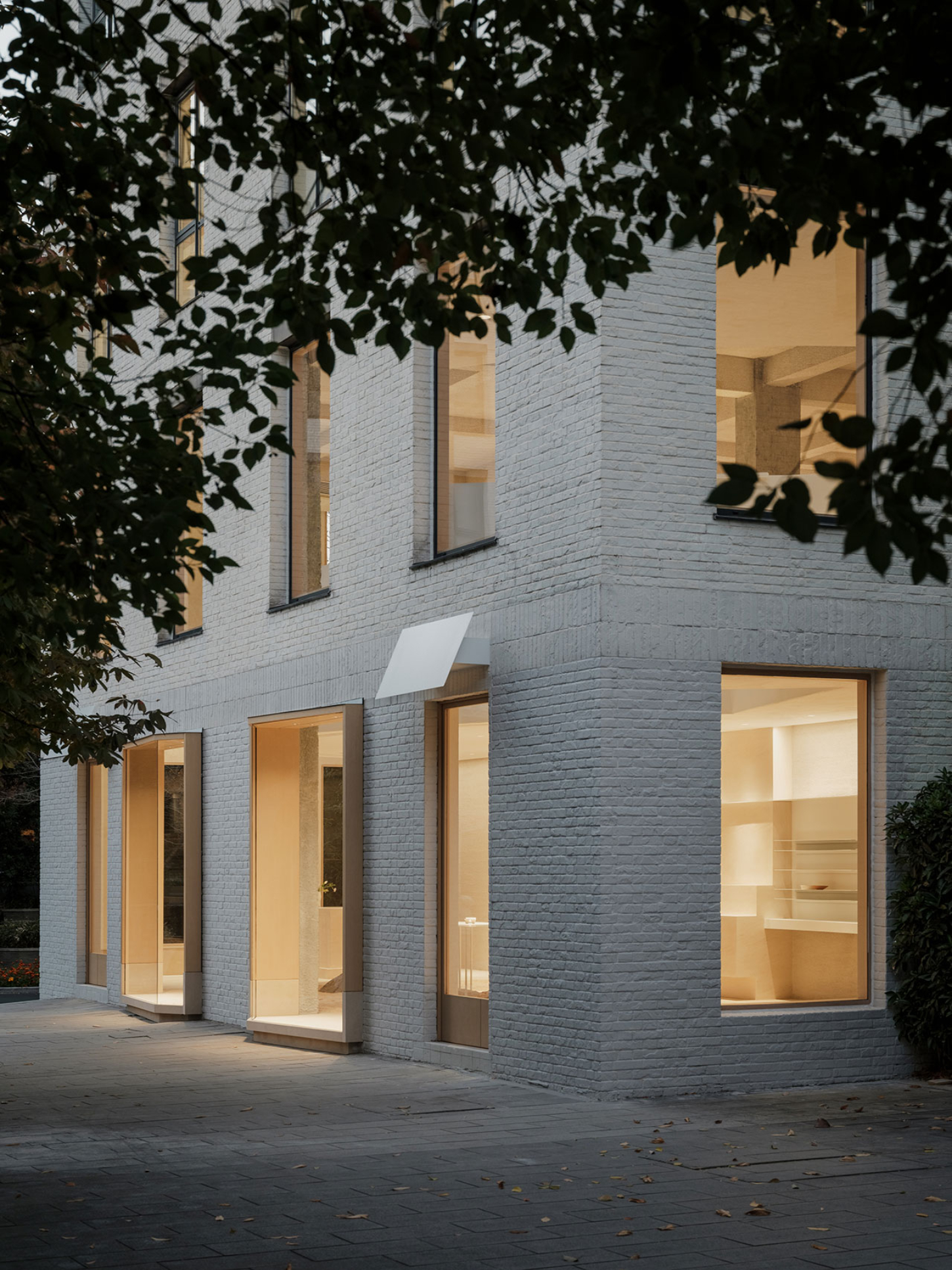 JIA Garden by Mountain Soil — Evening view of the JIA Garden retail facade in Hangzhou, captured from the courtyard threshold.