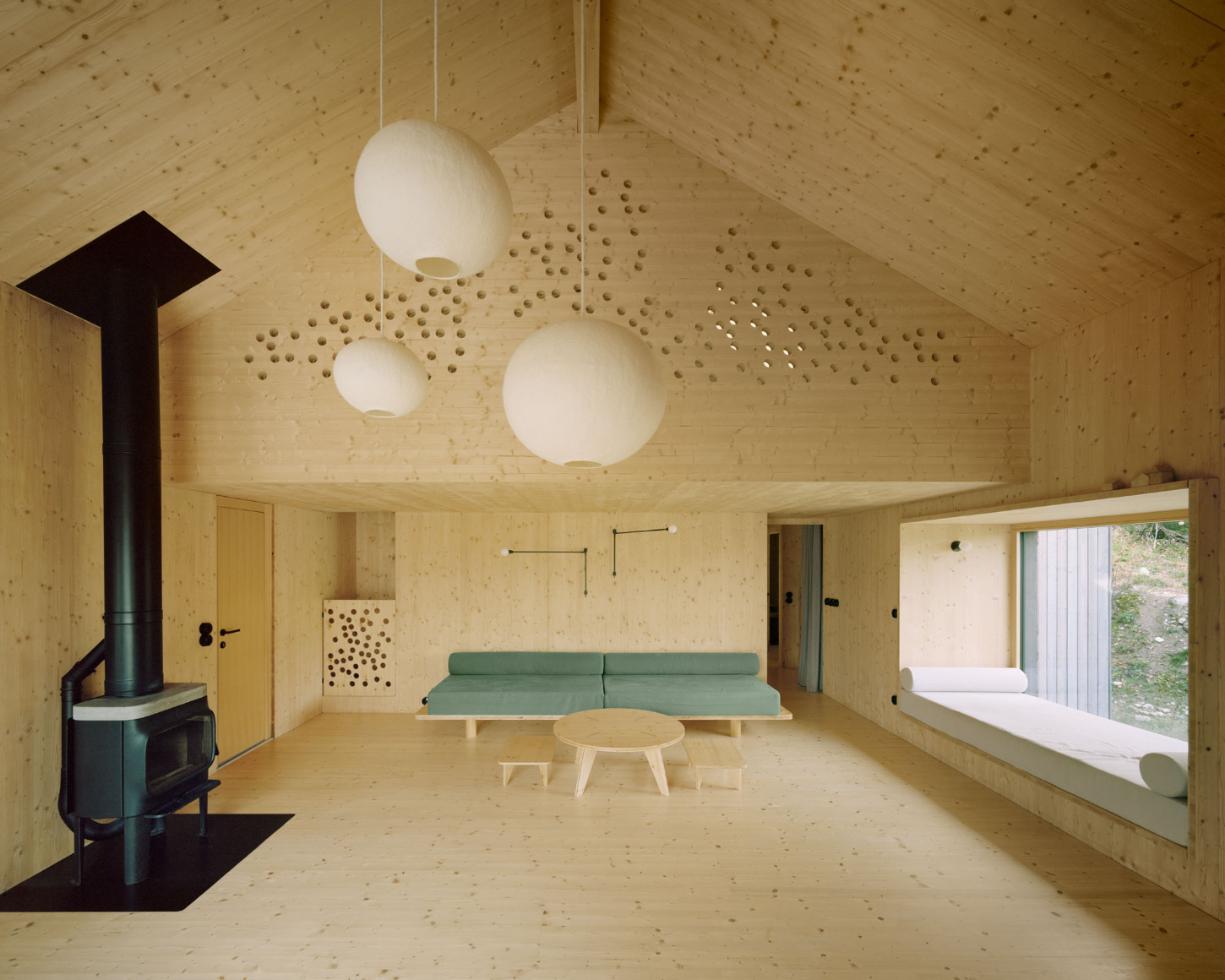 Maison Hiltiti captured by Rasmus Norlander by Atelier Ordinaire — A single open-plan interior volume reveals a weekend retreat constructed from cross-laminated timber, with exposed CLT visible across ceiling and wall...