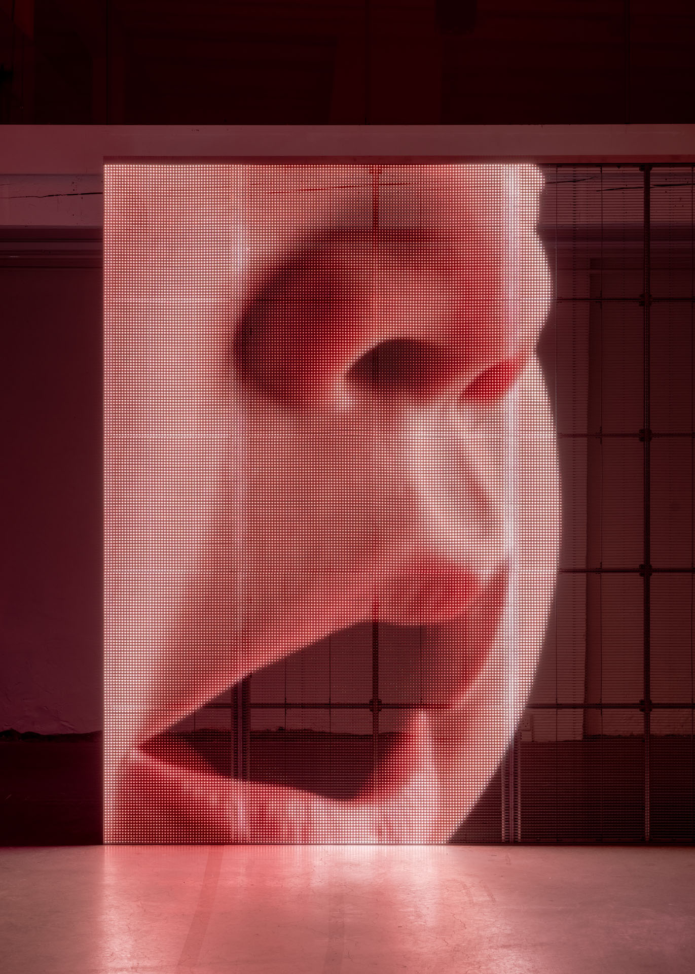 Milk Plus by Jens Settergren Viborg Kunsthal — A freestanding LED pixel display dominates the industrial gallery, emitting warm red monochromatic light across its grid surface.