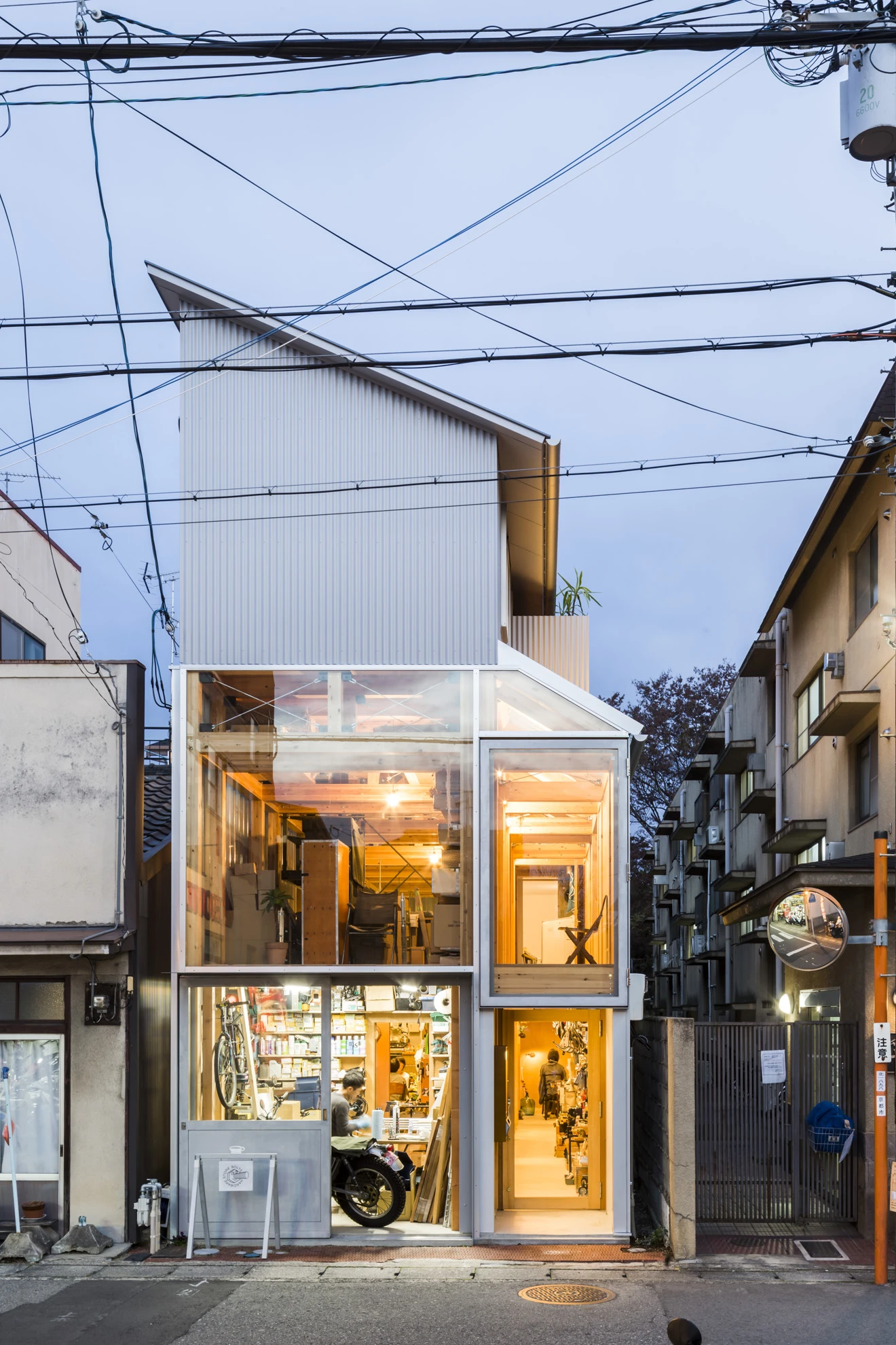 House A/Shop B (Bolts Hardware Store) by KimuraMatsumoto Architects — A narrow storefront in Kyoto's dense residential fabric, photographed at dusk.