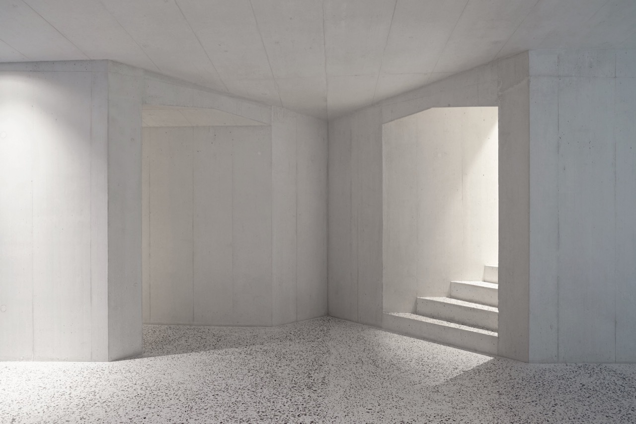 House in Laax by Valerio Olgiati — Interior view of concrete volume with board-formed finish revealing horizontal panel divisions across walls and ceiling.