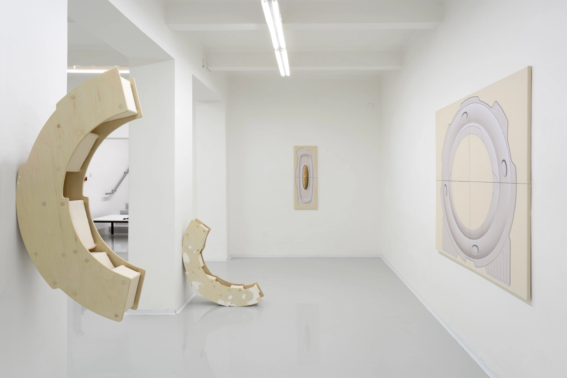 [face_not_recognized] by Milan Vagač — A gallery installation featuring three distinct wooden sculptural elements in pale cream and natural timber tones.
