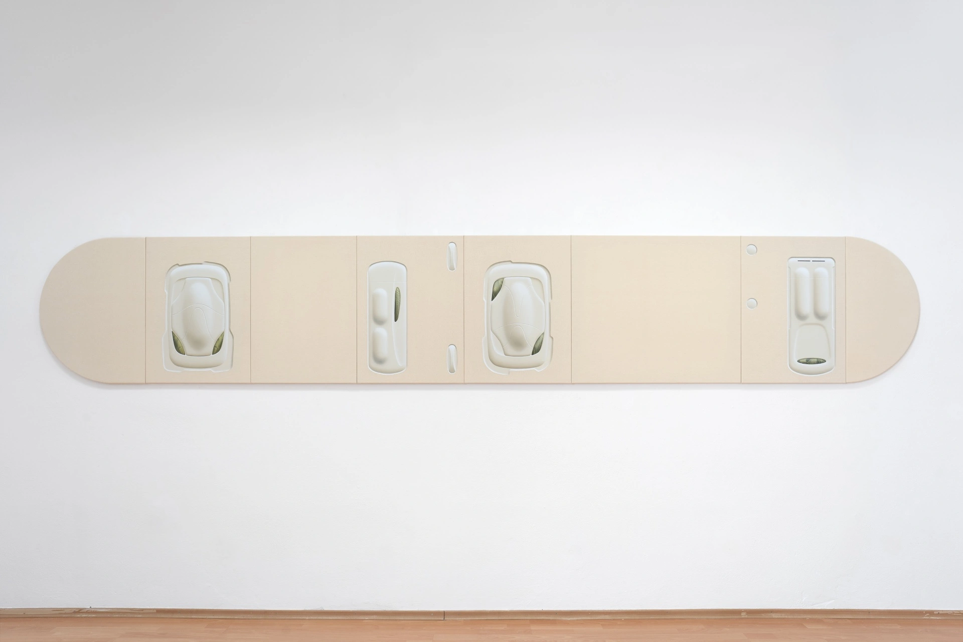 [face_not_recognized] by Milan Vagač — Vagač's wall-mounted installation presents four abstracted car silhouettes embedded within a cream-colored plaster or cast panel.