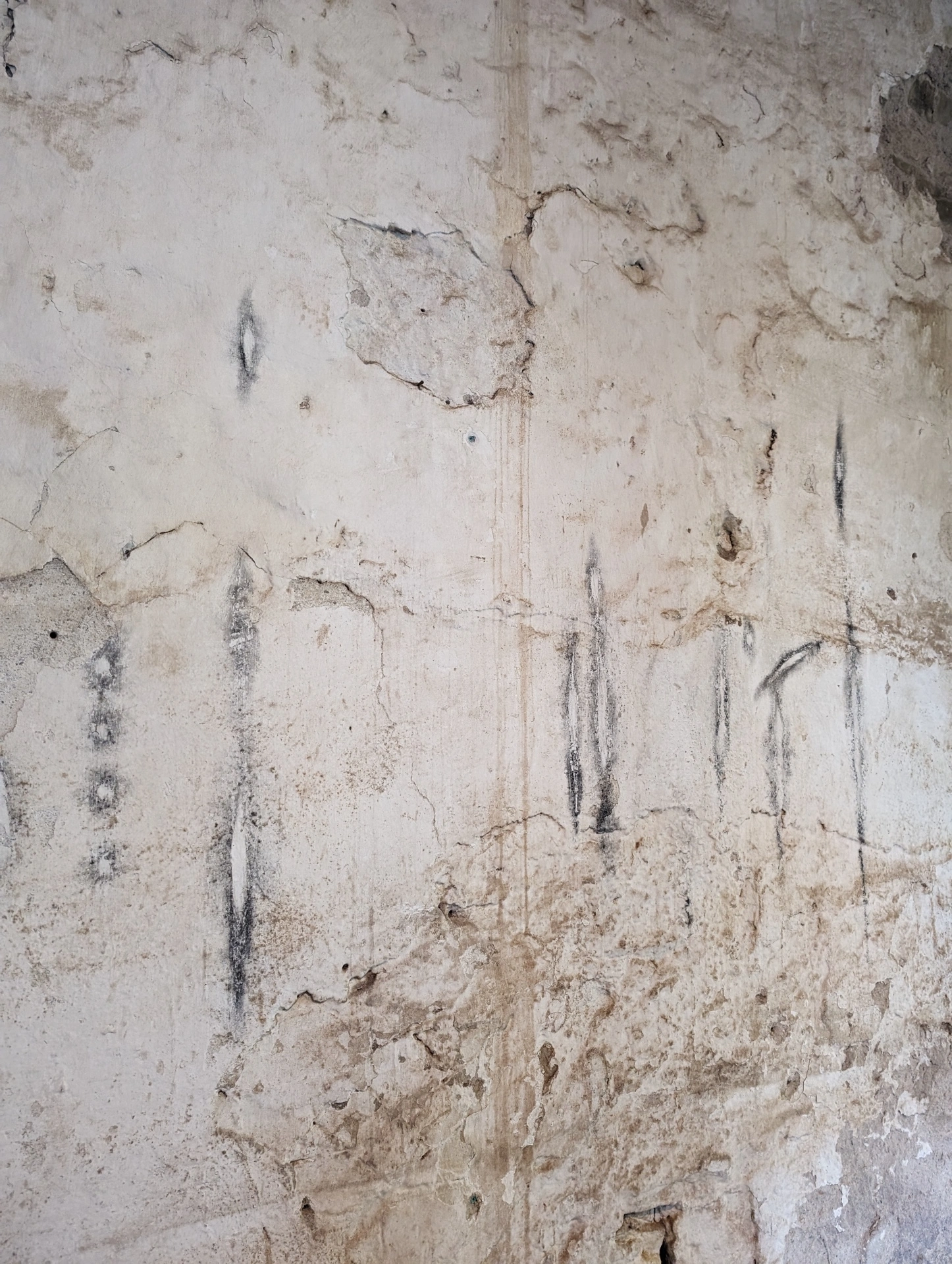 remember member ember by Carolina Aguirre at THE MILL — A close-up view of the installation's three columnar concrete forms photographed from a low angle against a weathered concrete wall.