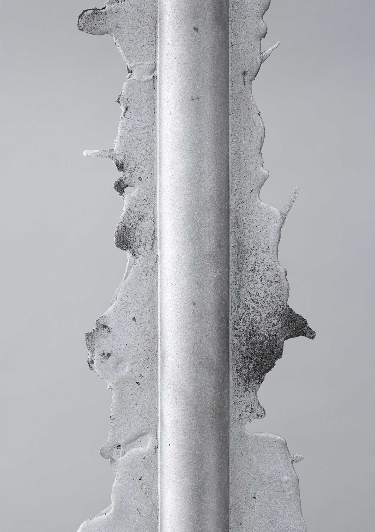 Vessels of Imperfection by Anna Zimmermann — A close-up detail photograph isolates a single cast aluminum vessel, revealing the full vertical extent of its production seam.