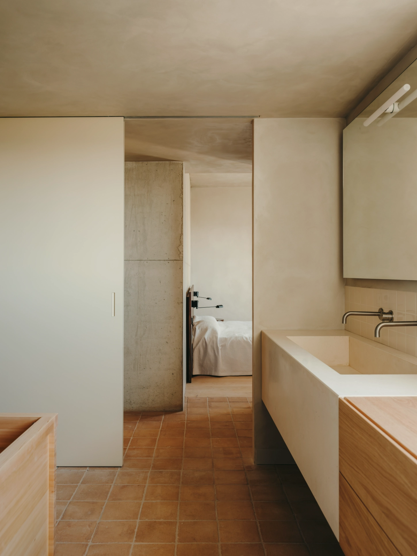 Casa TD by Skye Maunsell, Jordi Veciana and Juan Gurrea Rumeu — The bathroom extends the project's material restraint through a sequence of timber and plaster volumes.