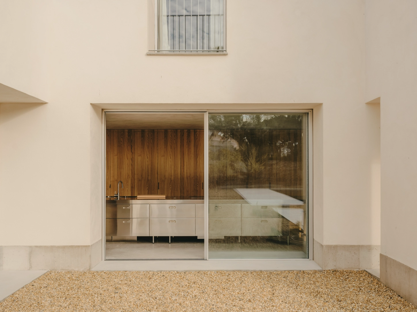 Casa TD by Skye Maunsell, Jordi Veciana and Juan Gurrea Rumeu — A sliding glass threshold frames the kitchen's functional clarity.