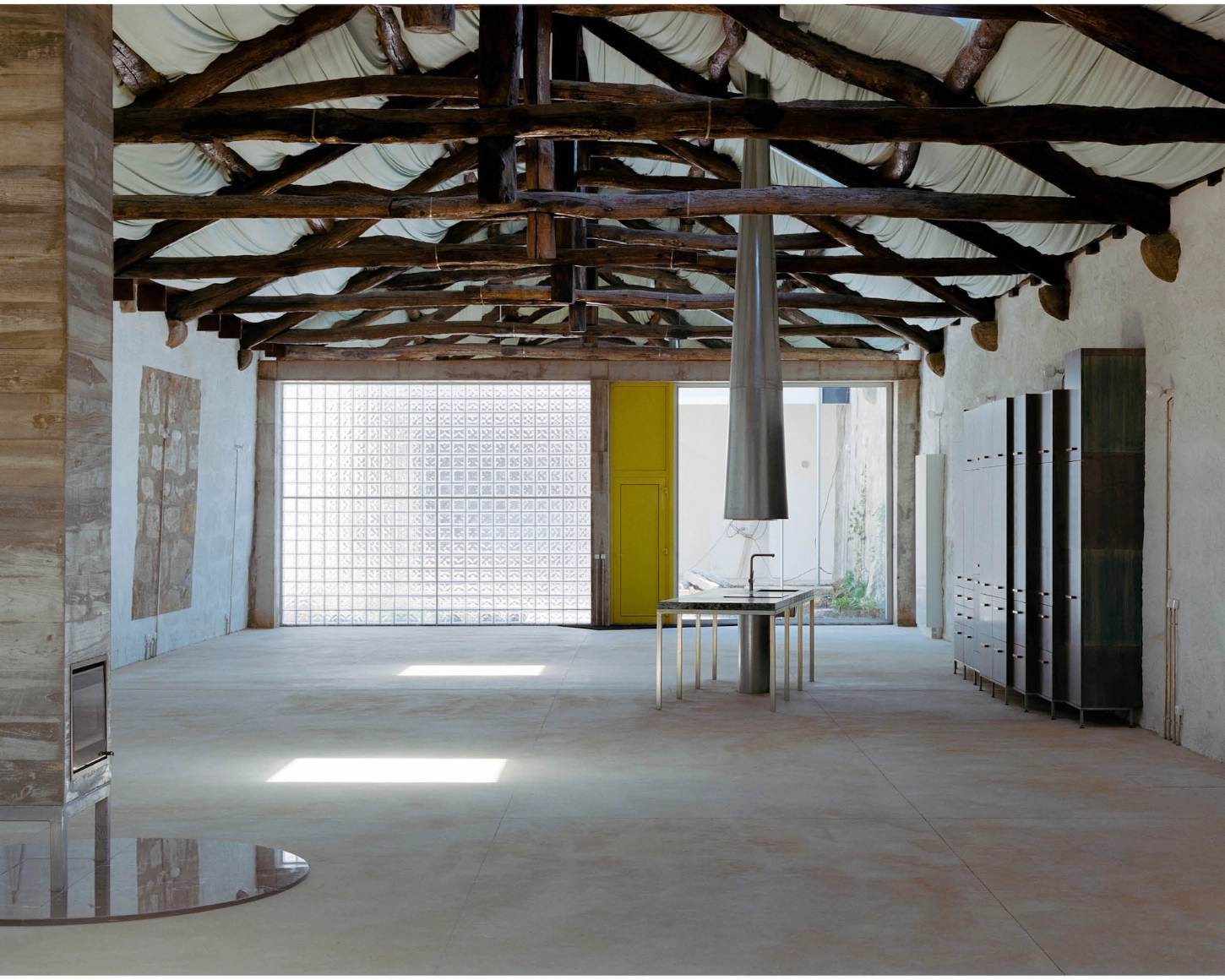 'House with many faces' by Fala Atelier — A capacious interior volume anchored by a central steel cylindrical column that rises through the full height of the space.
