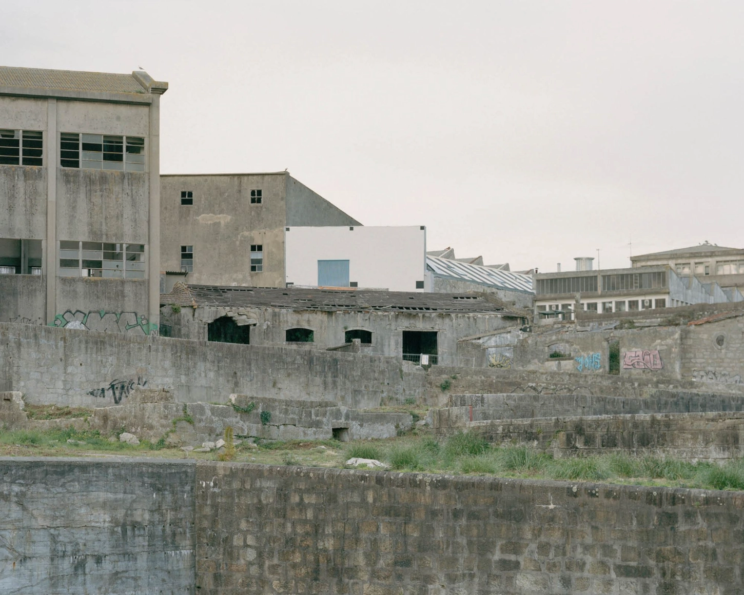 'House with many faces' by Fala Atelier — Waterside industrial structures in varying states of use and disrepair reveal Porto's layered urban fabric.