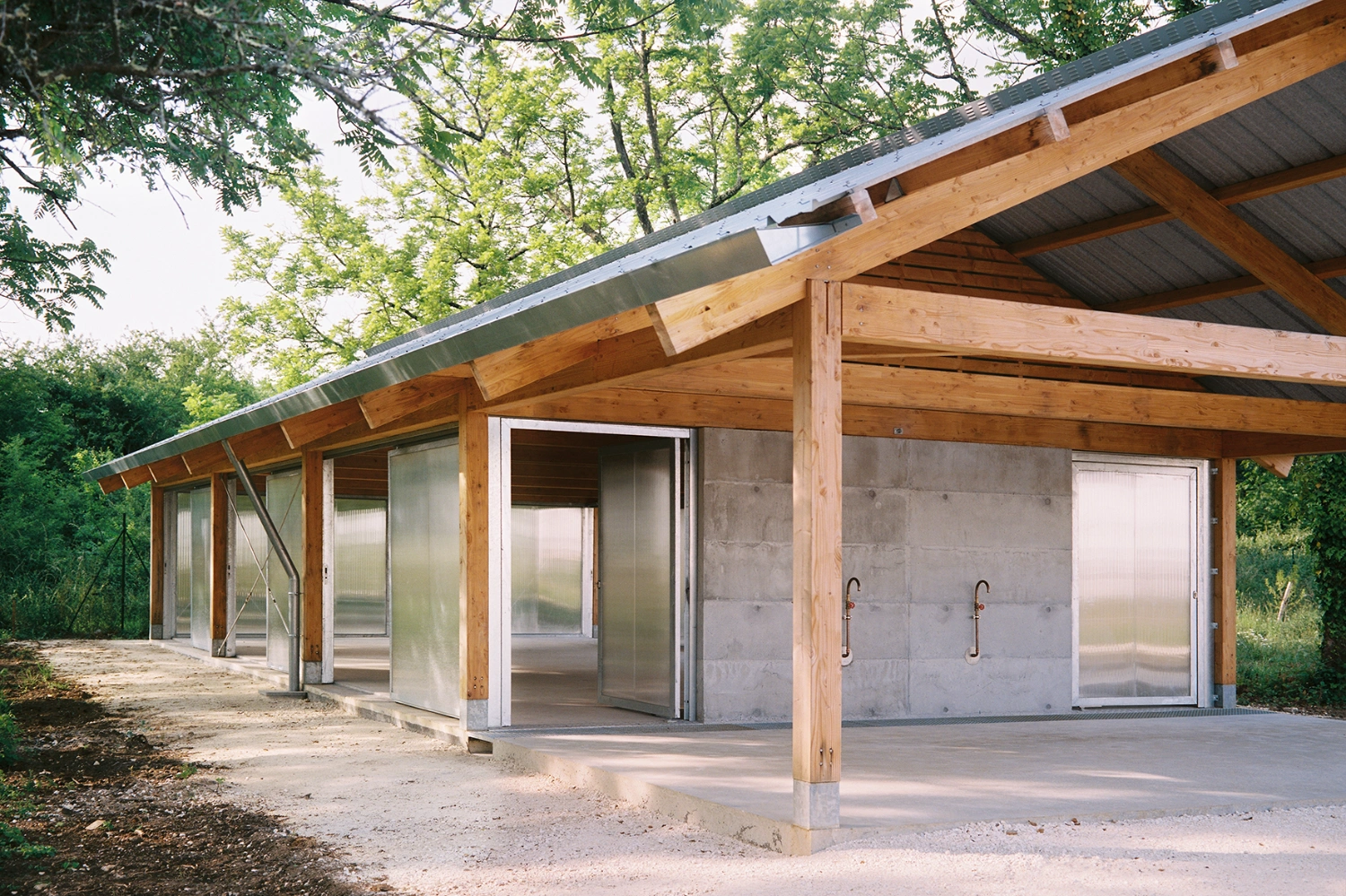 Garden Pavilion by Esnard Sanz Architectes — A timber-framed garden pavilion with gabled roof and exposed horizontal slats in the pediment.