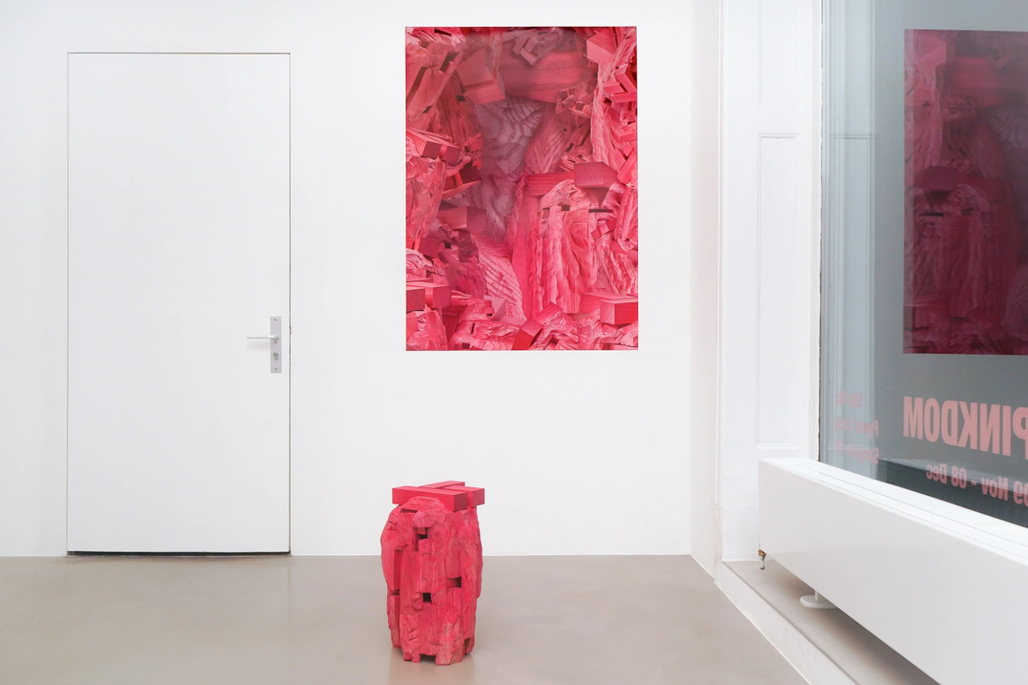 PINKDOM by Knit Pigment — A carved wooden sculpture dominates the gallery floor, its anthropomorphic form rendered entirely in hot pink.