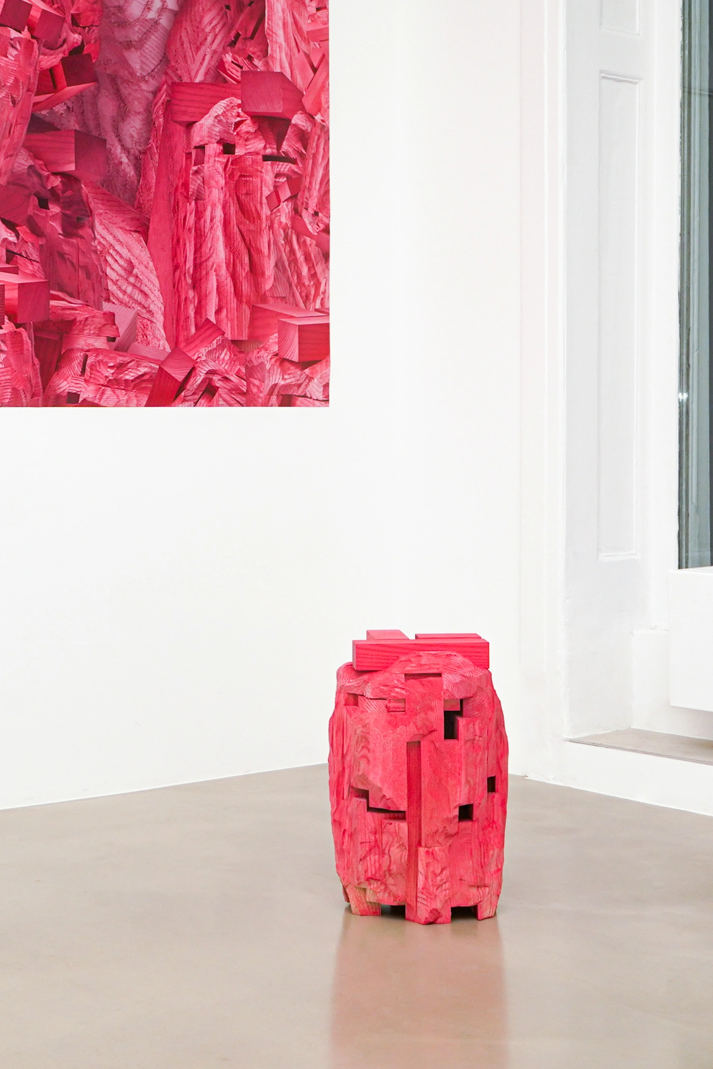 PINKDOM by Knit Pigment — A carved wooden sculpture painted hot pink stands alone on a polished concrete floor in a white-walled gallery space.