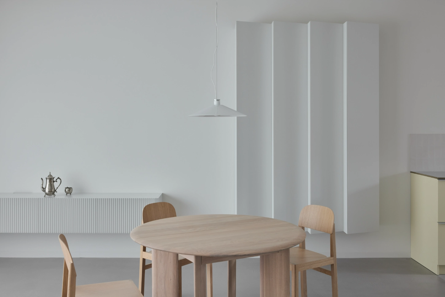 VVV by i.B Archstudio — A dining area centered on a light oak round table with organic proportions, surrounded by bentwood chairs in natural finish.