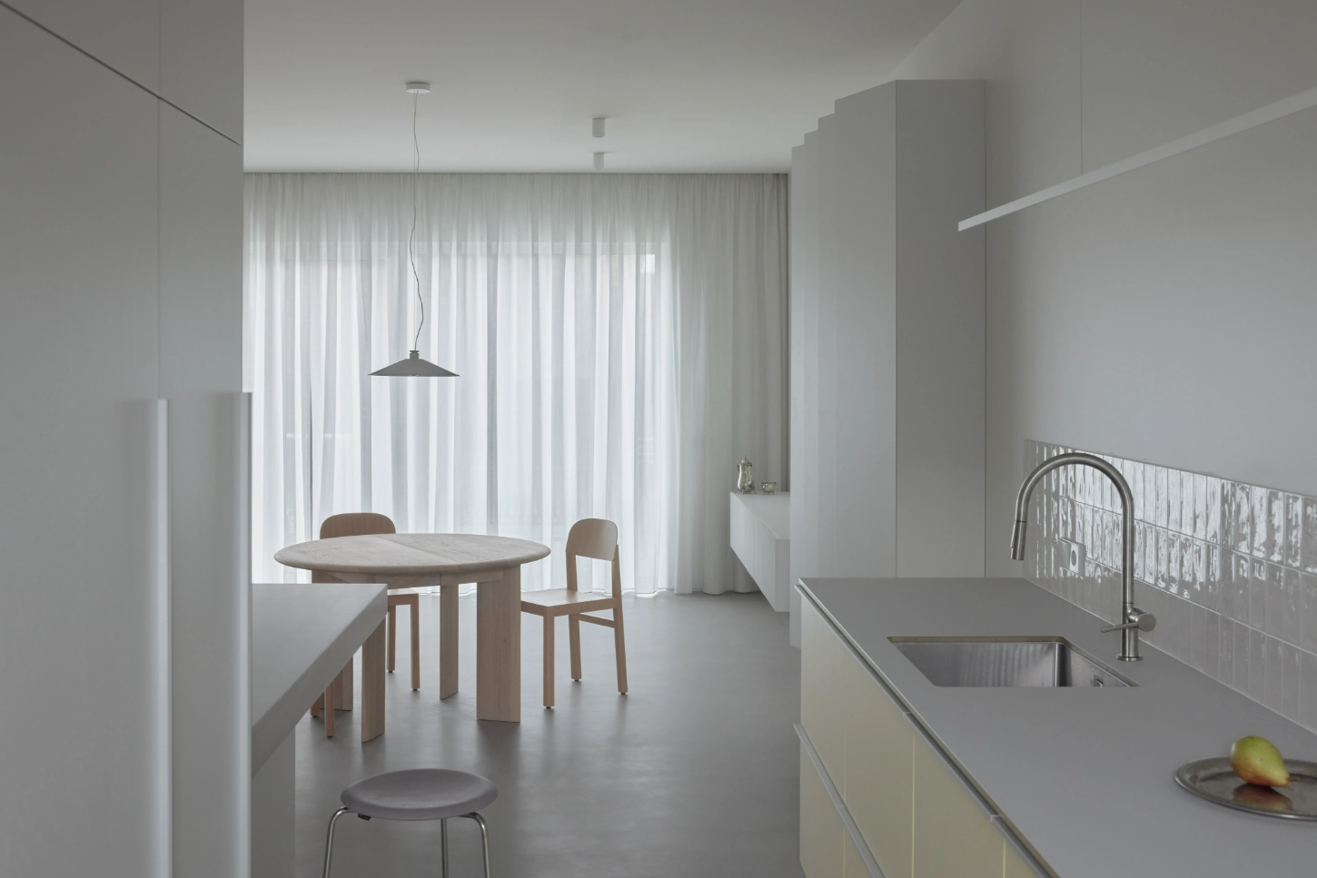 VVV by i.B Archstudio — VVV's open-plan kitchen and dining area demonstrates spatial continuity through material and chromatic restraint.