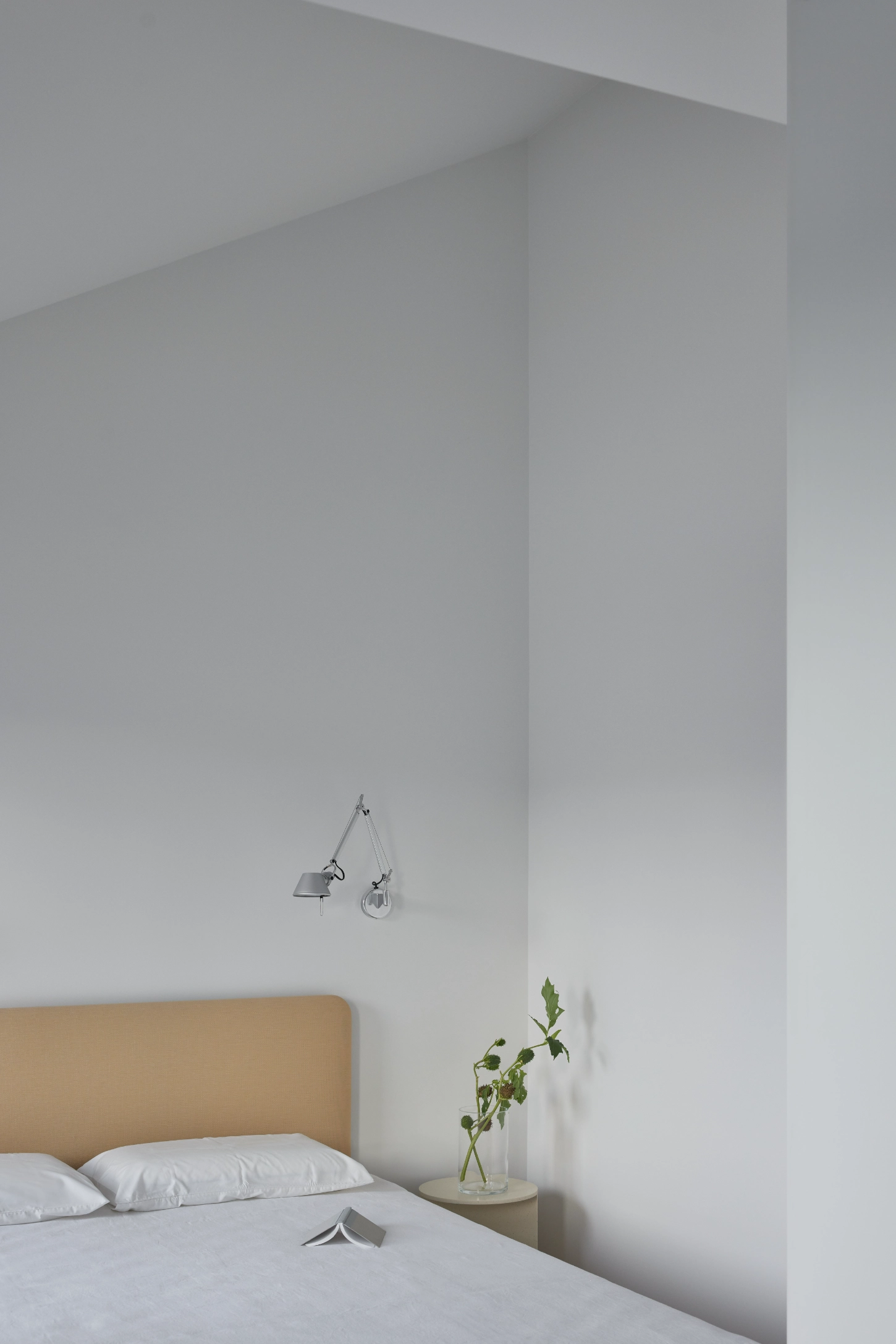 VVV by i.B Archstudio — A minimalist bedroom corner showcases the project's commitment to spatial flexibility through restrained material choices and functional design.