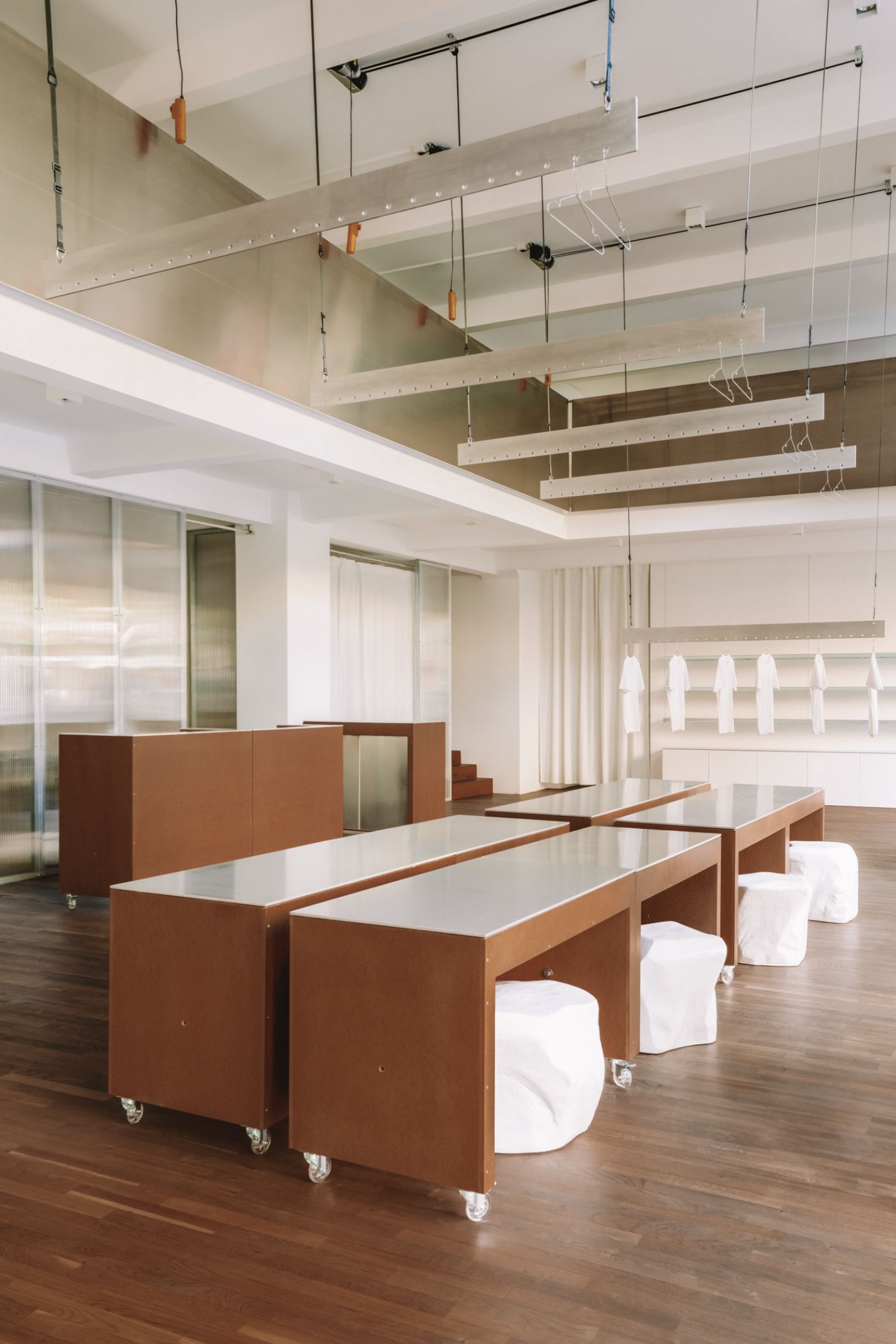 KMB Torstrasse 140 by Vaust — A flexible workspace designed around two symmetrical mobile carts with oiled timber frames and white laminate work surfaces, positioned on casters for...