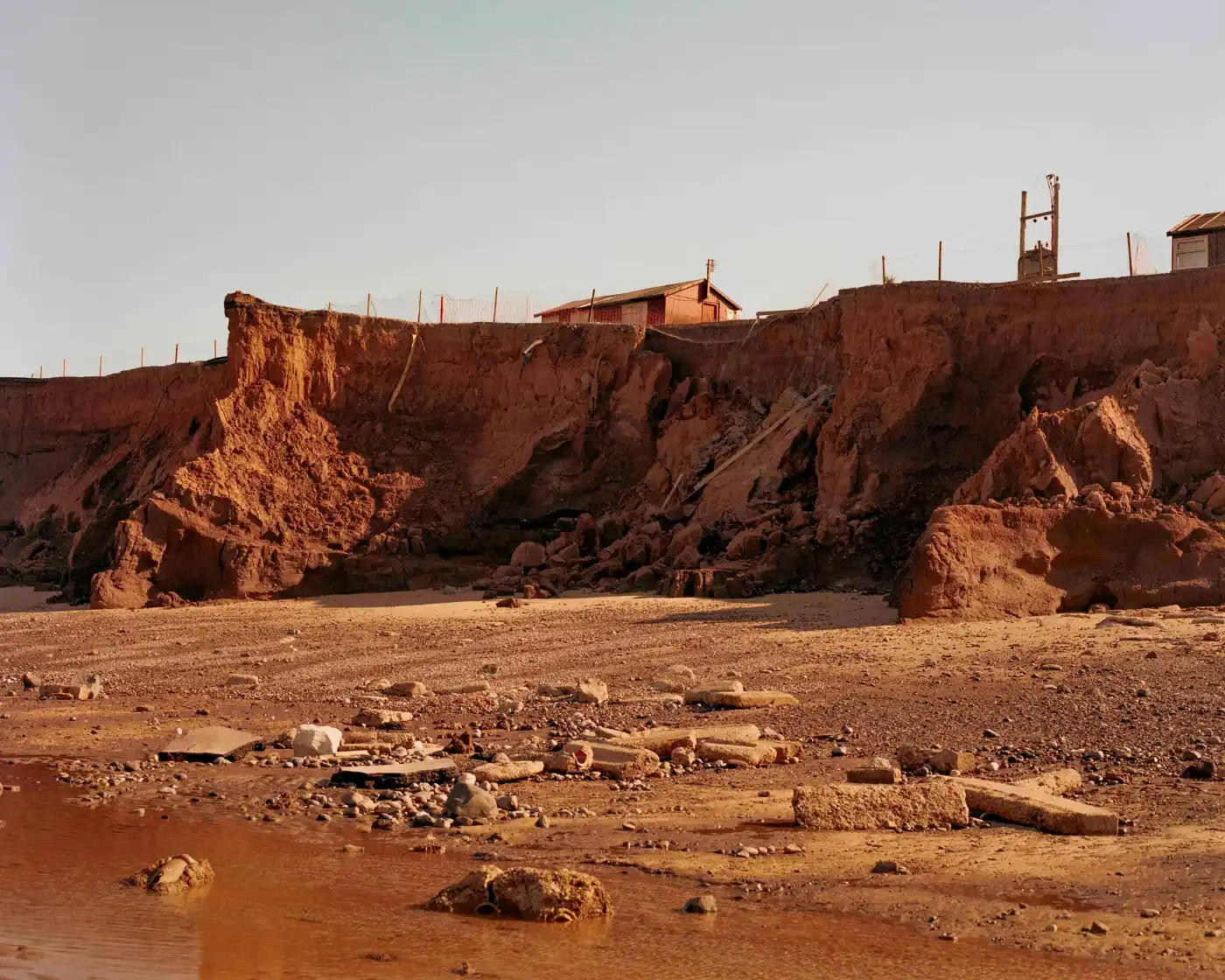 Land Loss by Max Miechowski — Coastal erosion documented through active subsidence affecting residential settlement.