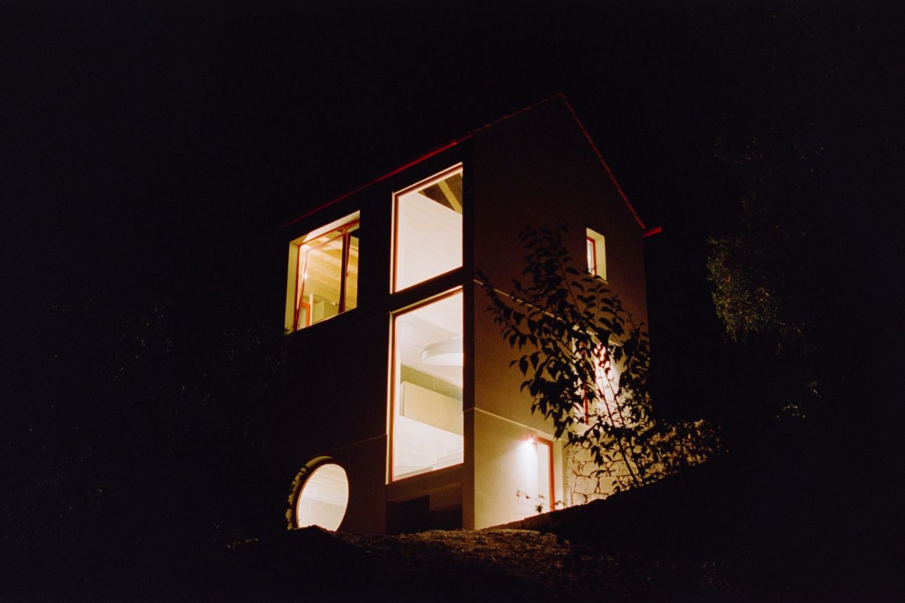 House in Ancede by atelier local — Night photograph of House in Ancede revealing interior spatial organization through illuminated windows.