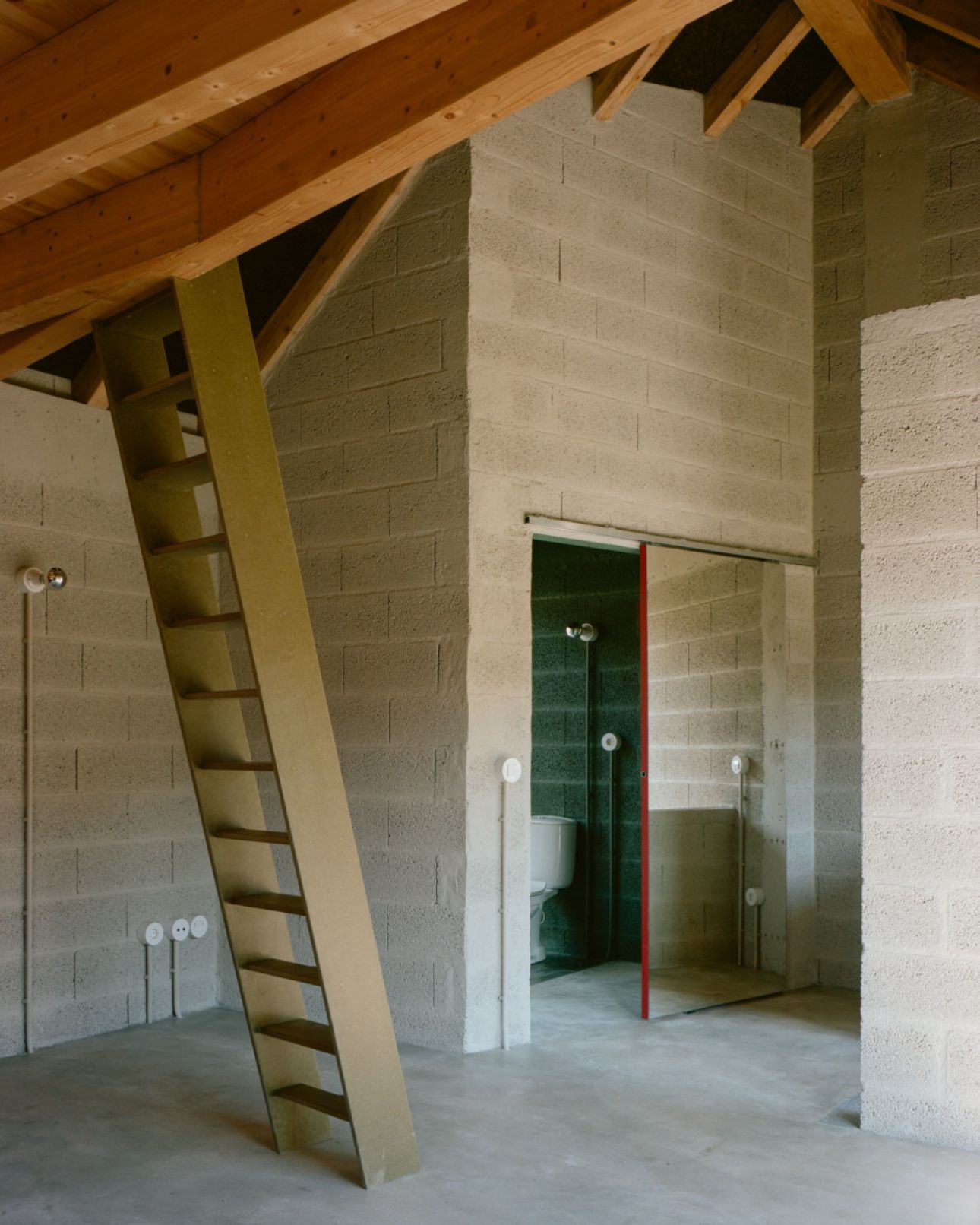 House in Ancede by atelier local — An unfinished interior space reveals the layered construction of House in Ancede.
