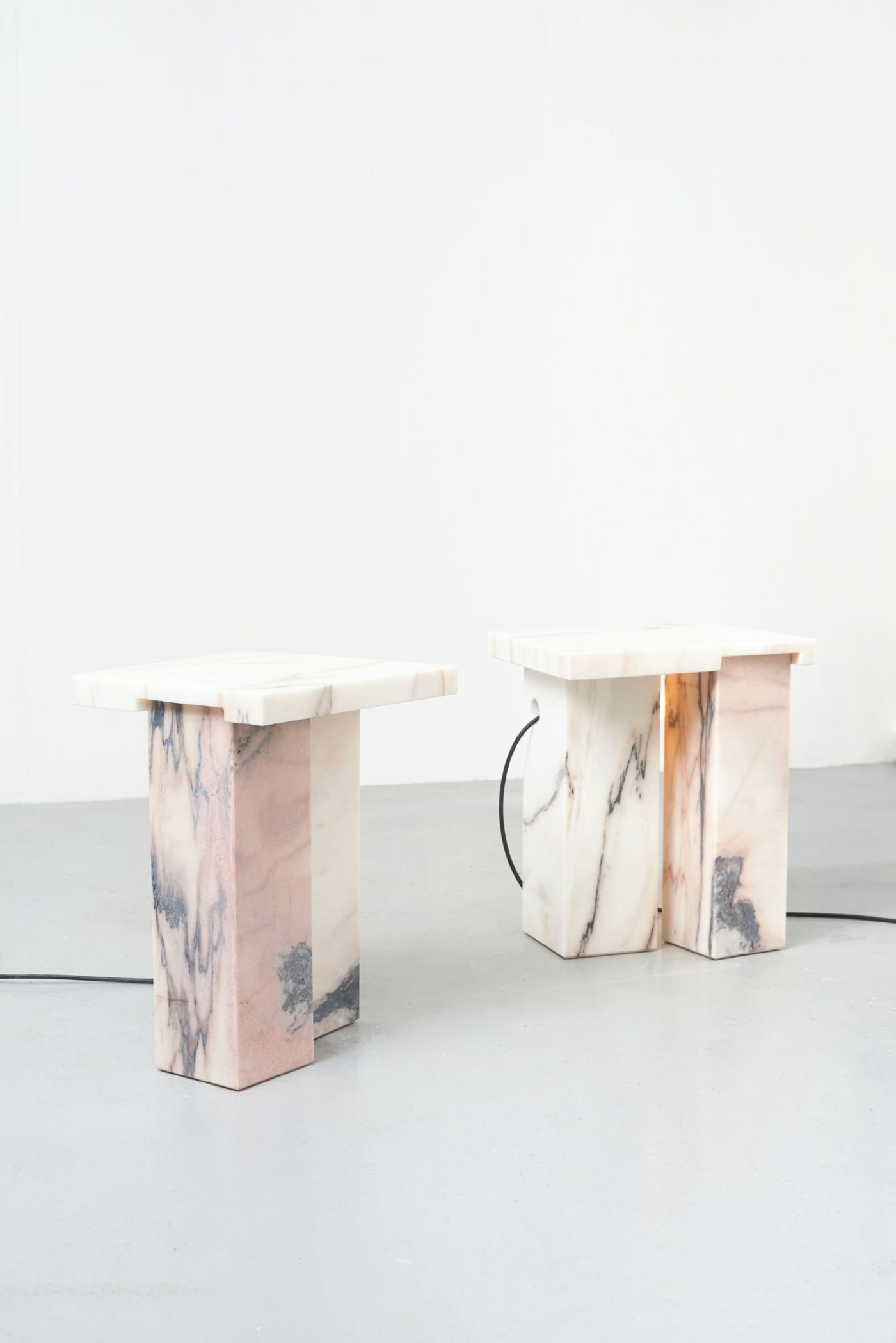 Selected Works by Bahraini-Danish — A sculptural table featuring two pedestals with organic cutout handles and undulating wave-form edges along the top surface.