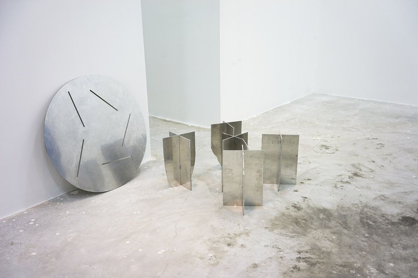 Selected Works by Bahraini-Danish — A sculptural installation comprises two distinct metal elements within a raw concrete gallery space.