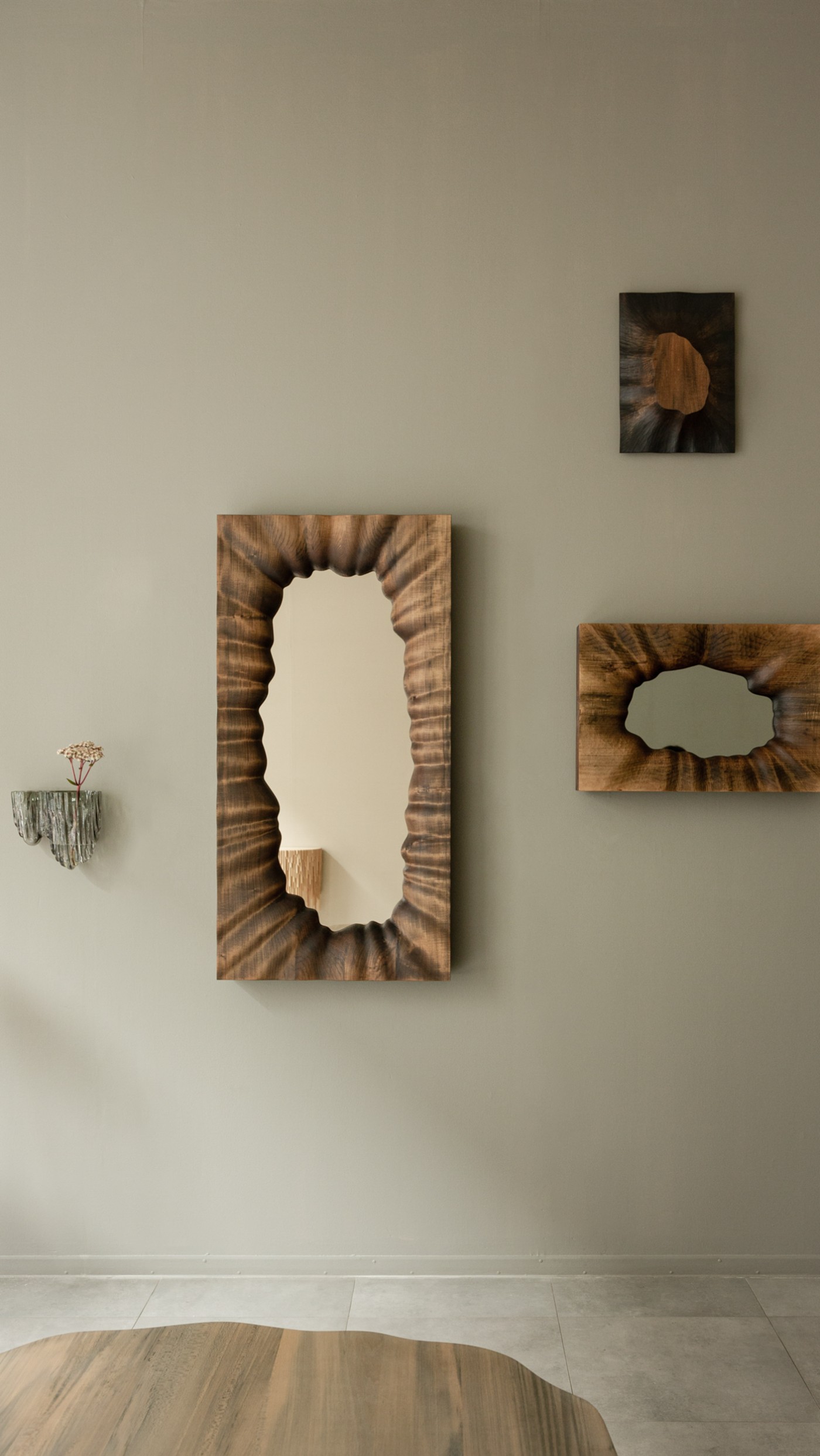 TRACES Exhibition by Antrei Hartikainen — Three wooden wall-mounted sculptural objects with carved void apertures dominate the gallery wall.