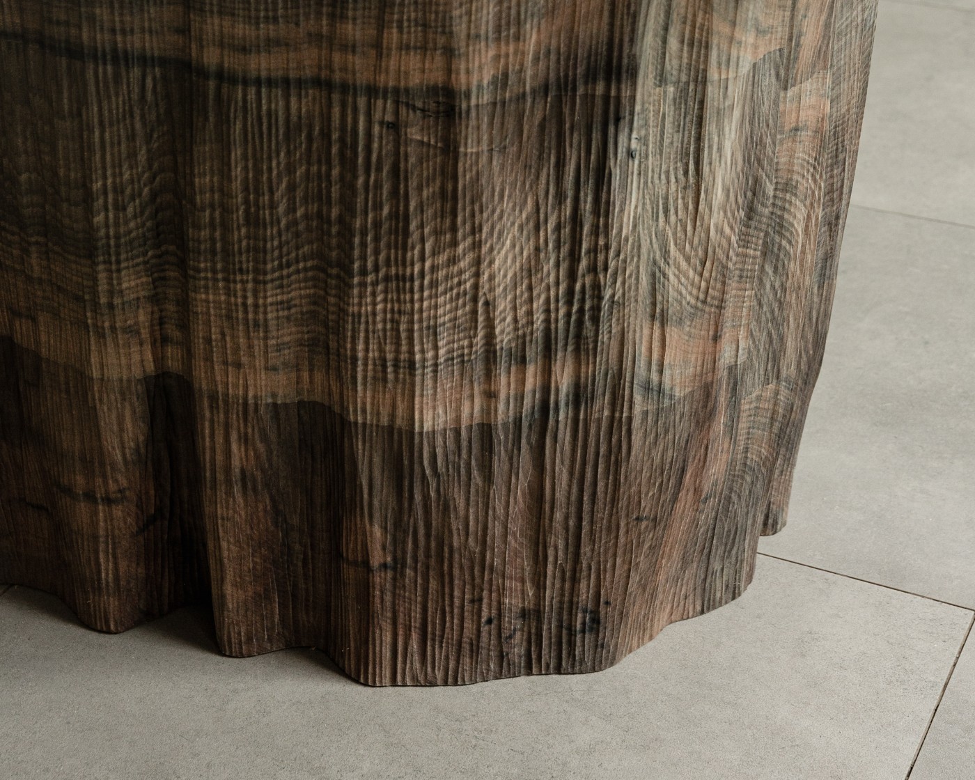 TRACES Exhibition by Antrei Hartikainen — Suspended wooden slats of graduated lengths cascade downward from a horizontal rail, creating an irregular fringe-like installation.