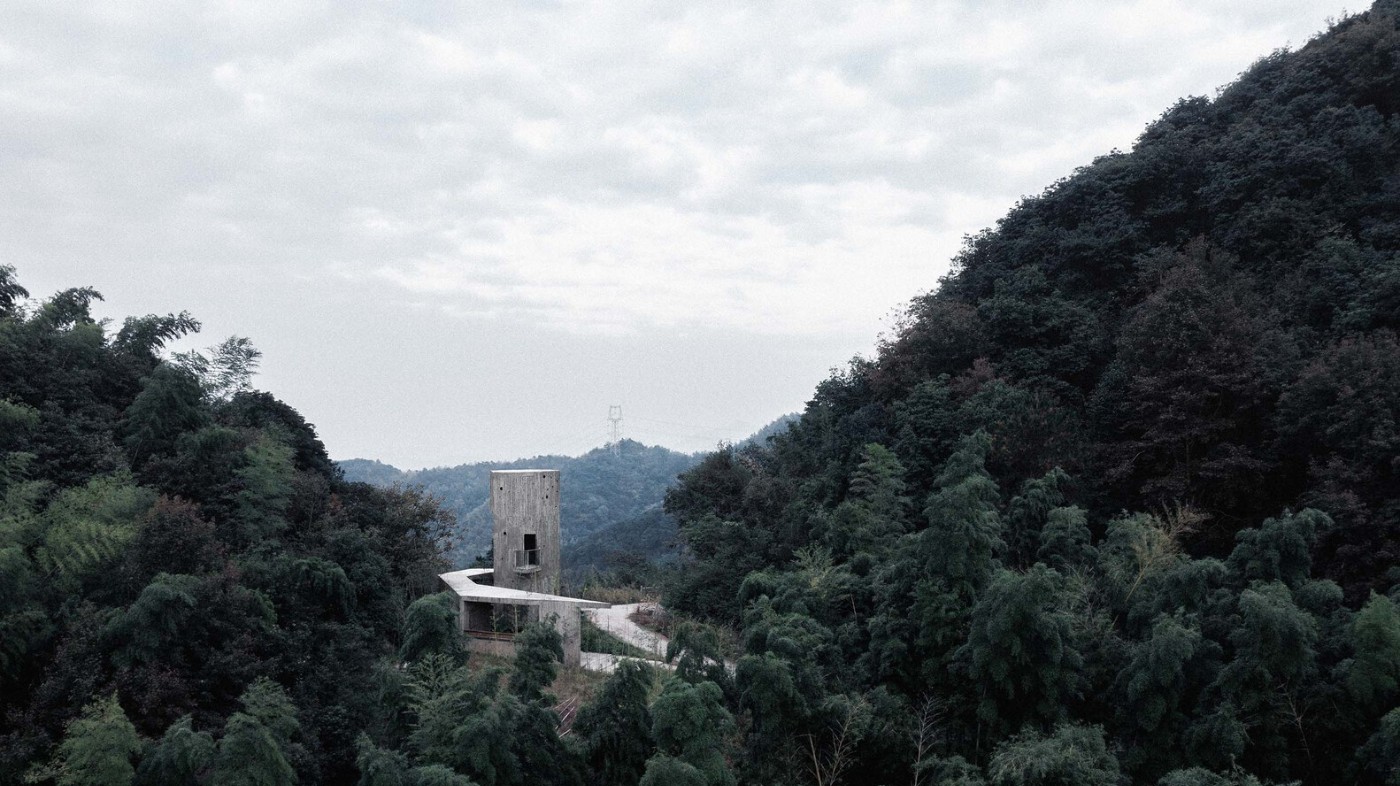 Rest station by Jumping House Lab — A concrete tower with cantilevered horizontal slab emerges from densely forested hillside in Shaoxing.