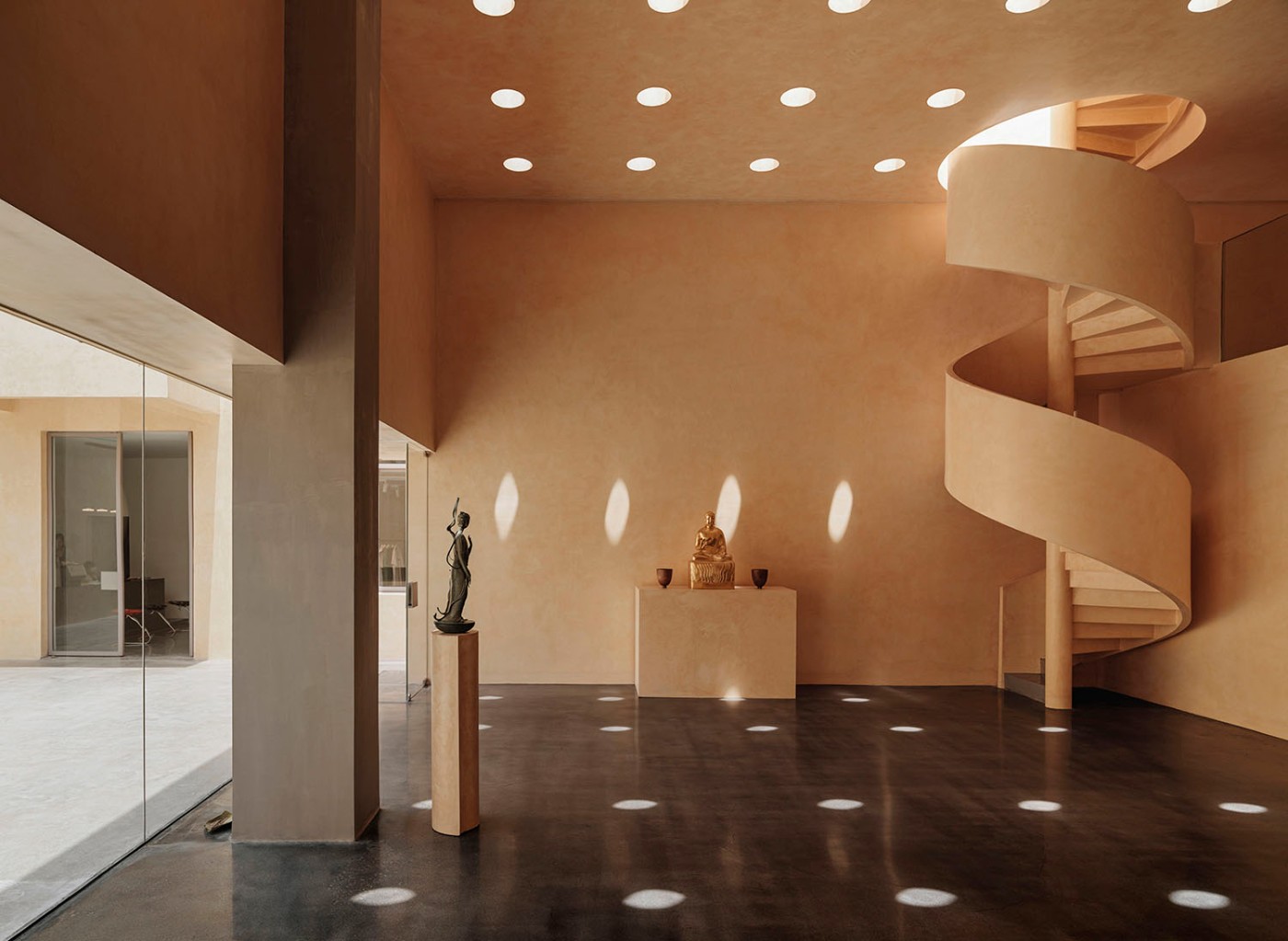 'The Field' by TEAM_BLDG by TEAM BLDG — A rendered gallery interior features warm sandalwood-yellow walls with visible surface texture, punctuated by recessed ceiling lights casting circular...