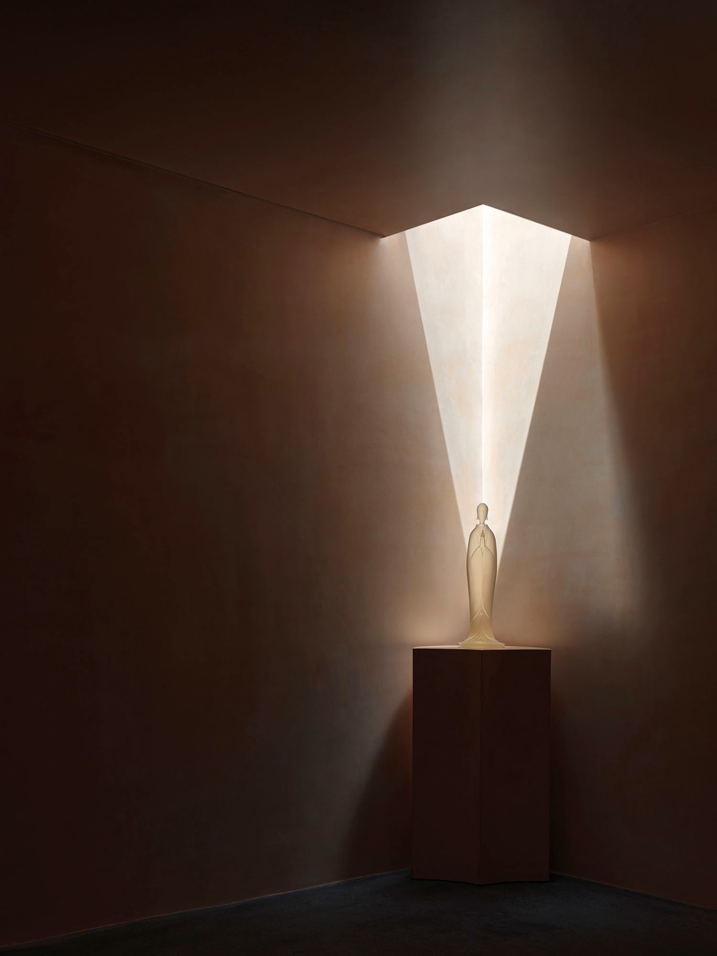 'The Field' by TEAM_BLDG by TEAM BLDG — A golden-hued figurative sculpture stands on a dark plinth within a double-height interior volume.